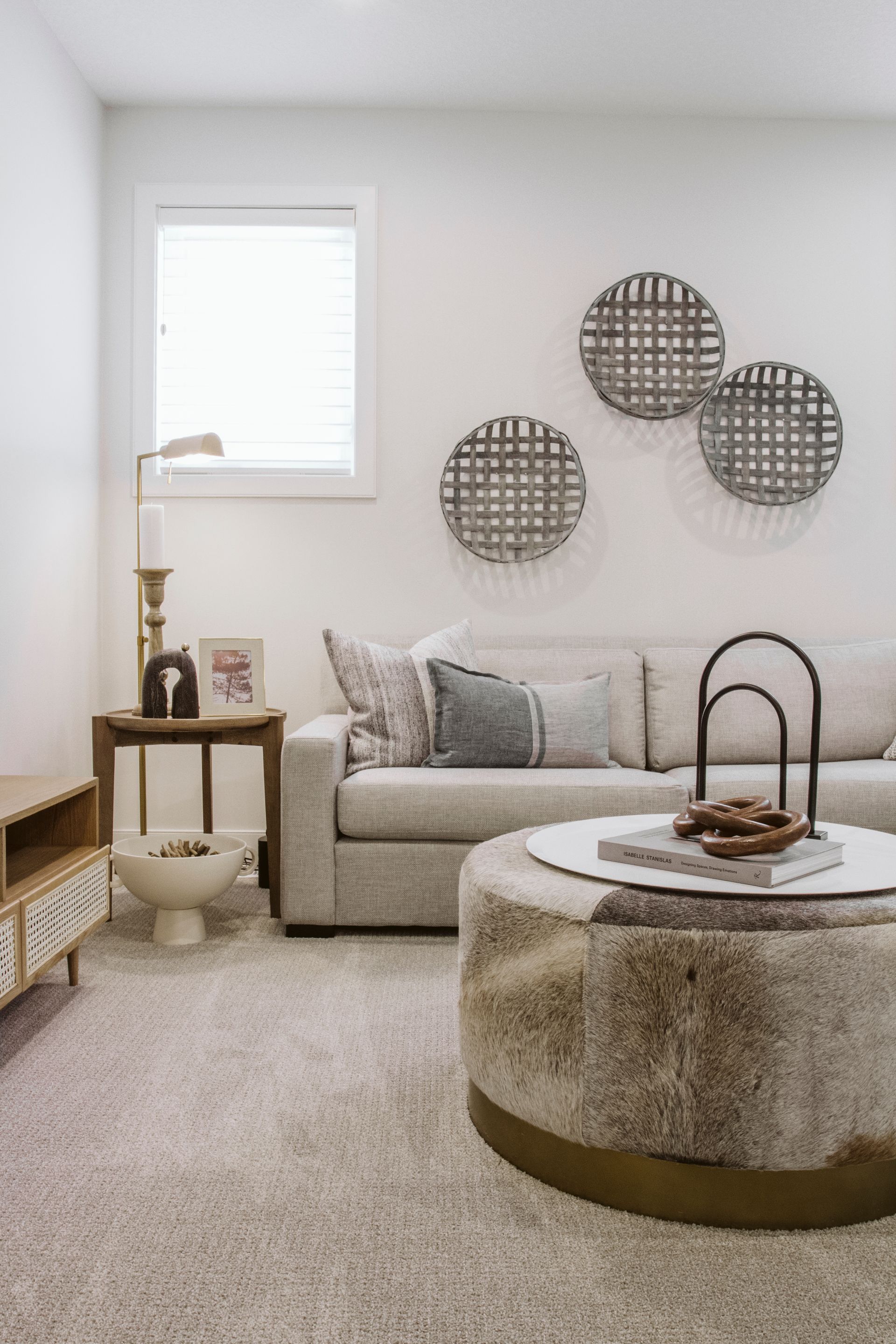 A living room with a couch , coffee table , and ottoman.