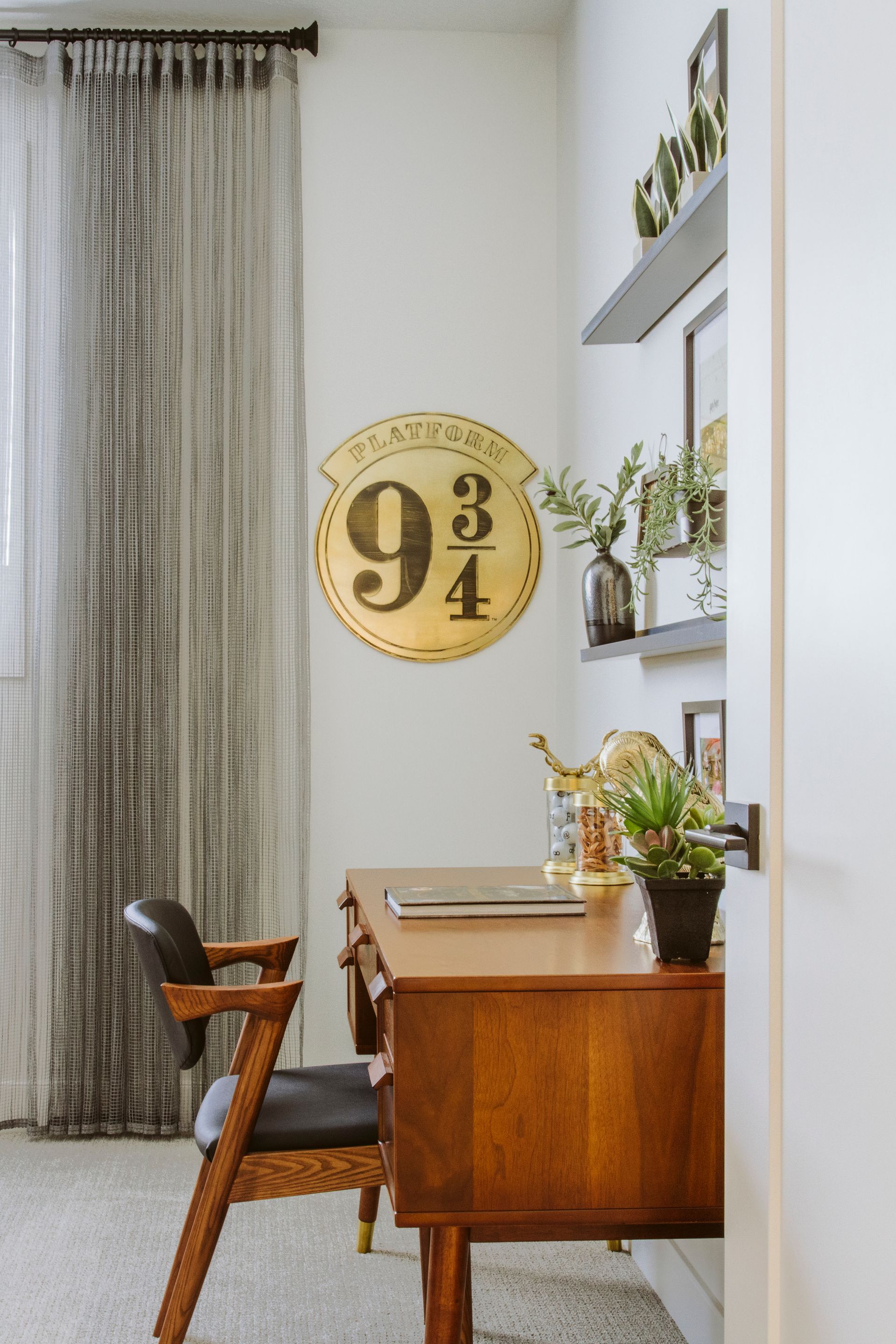 A room with a desk and chair and a sign on the wall.