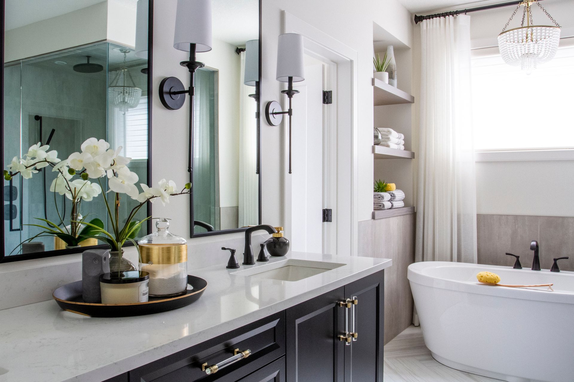A bathroom with two sinks , a bathtub , and a large mirror.