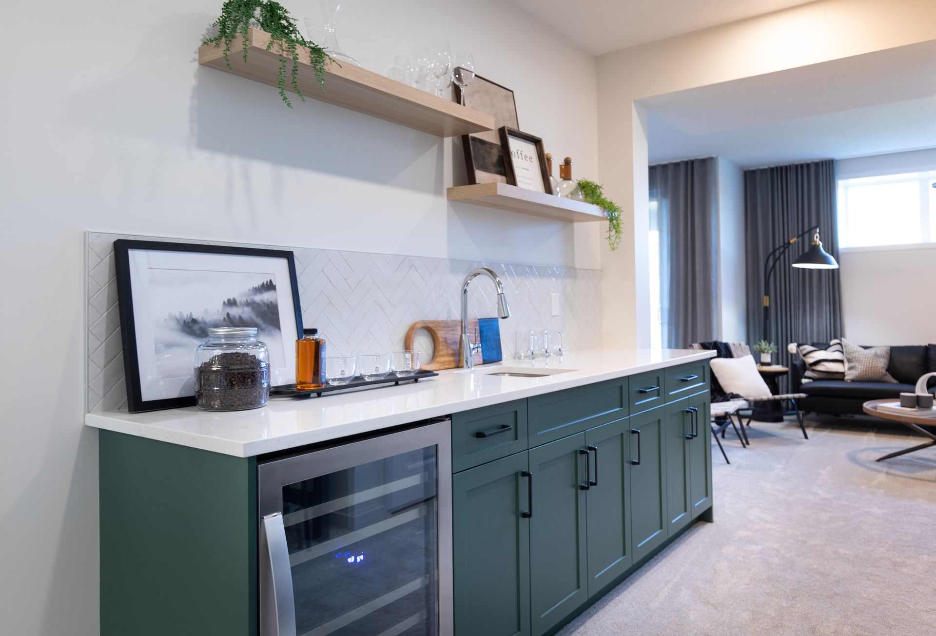 A kitchen with green cabinets and a wine cooler.