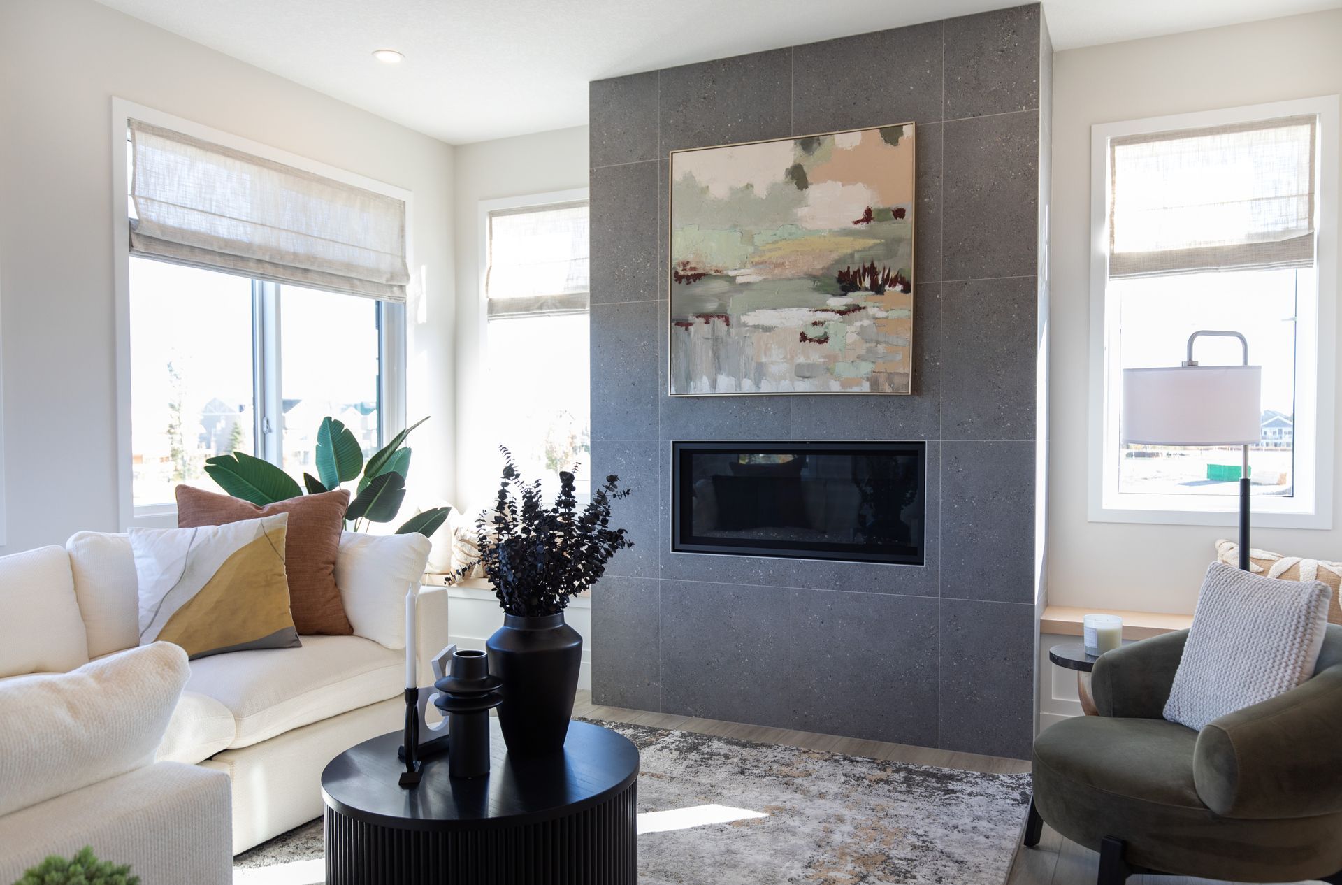 A living room with a couch , chair , table and fireplace.