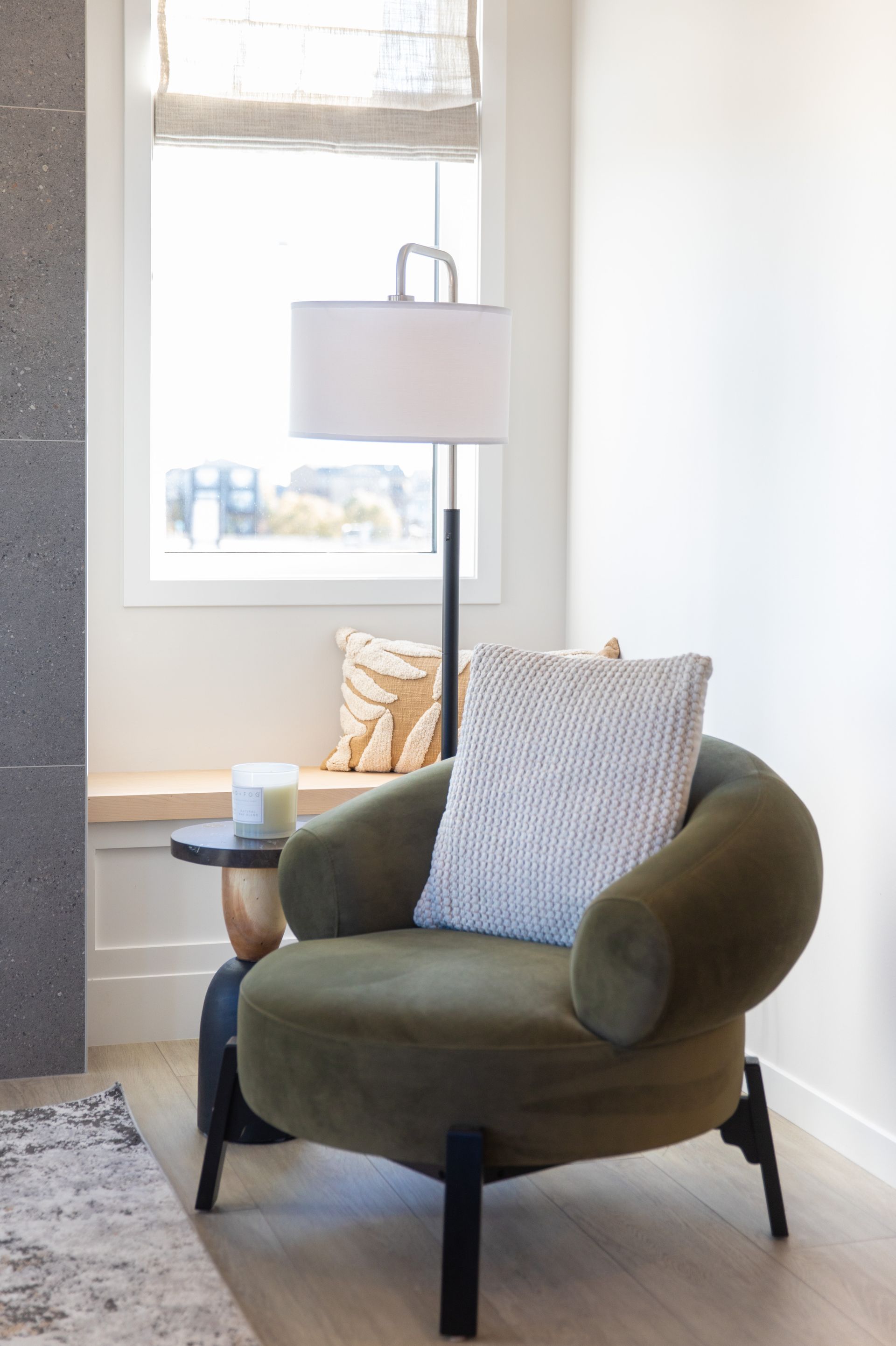 A living room with a green chair and a lamp