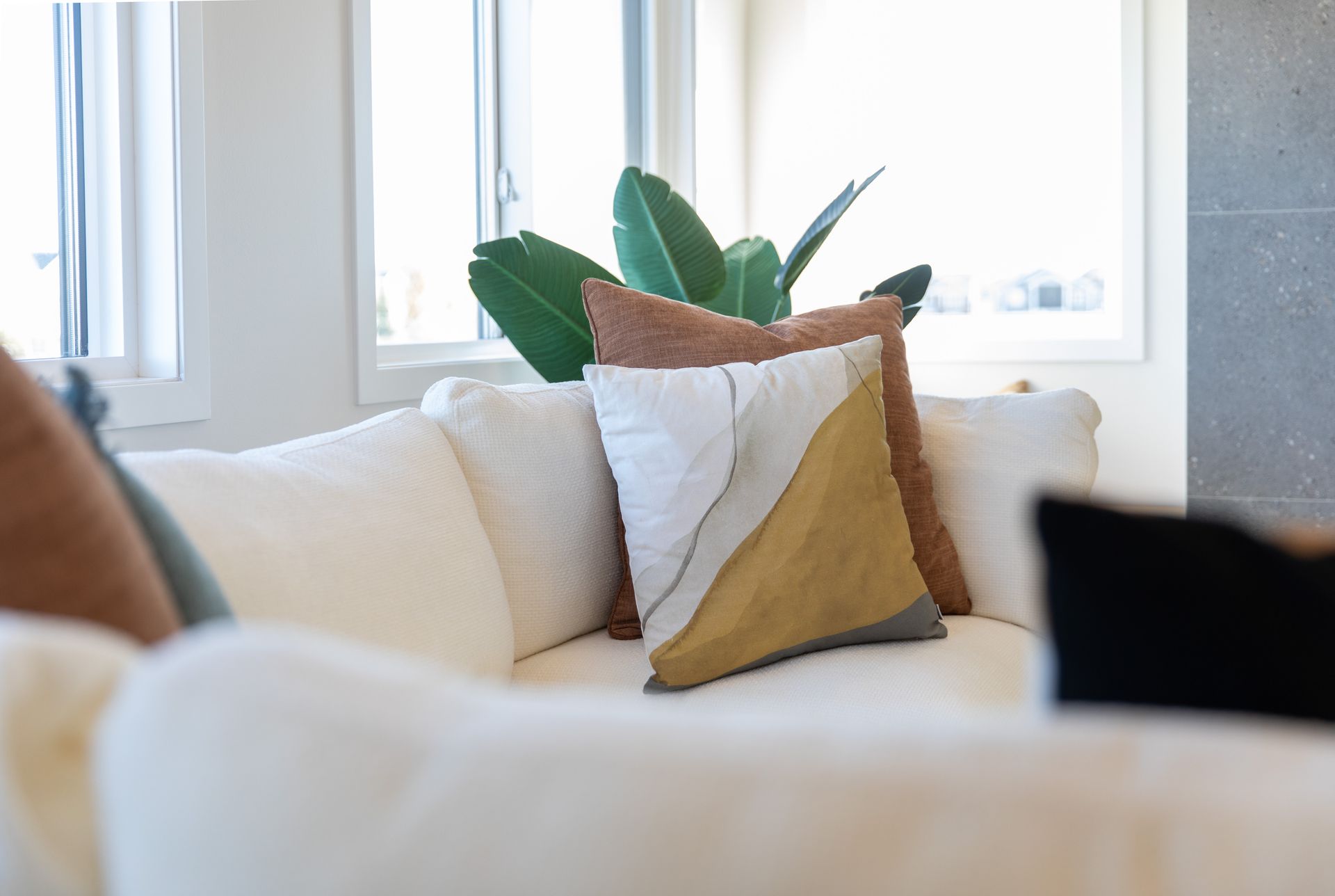 There are many pillows on the couch in the living room.