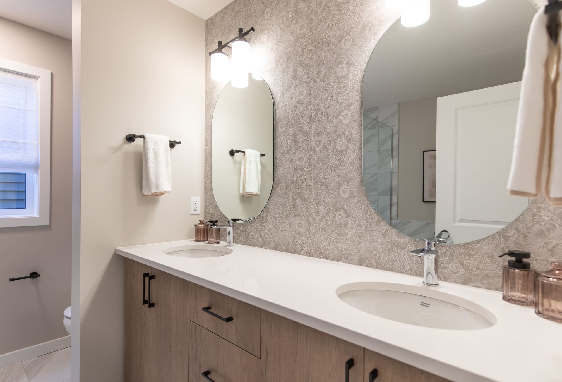 A bathroom with two sinks and two mirrors.