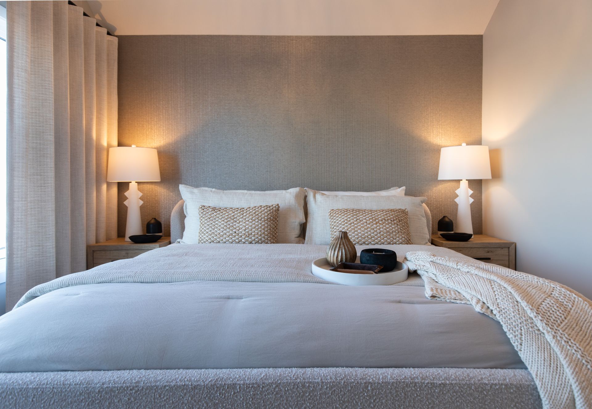 A bedroom with a bed , lamps and a window