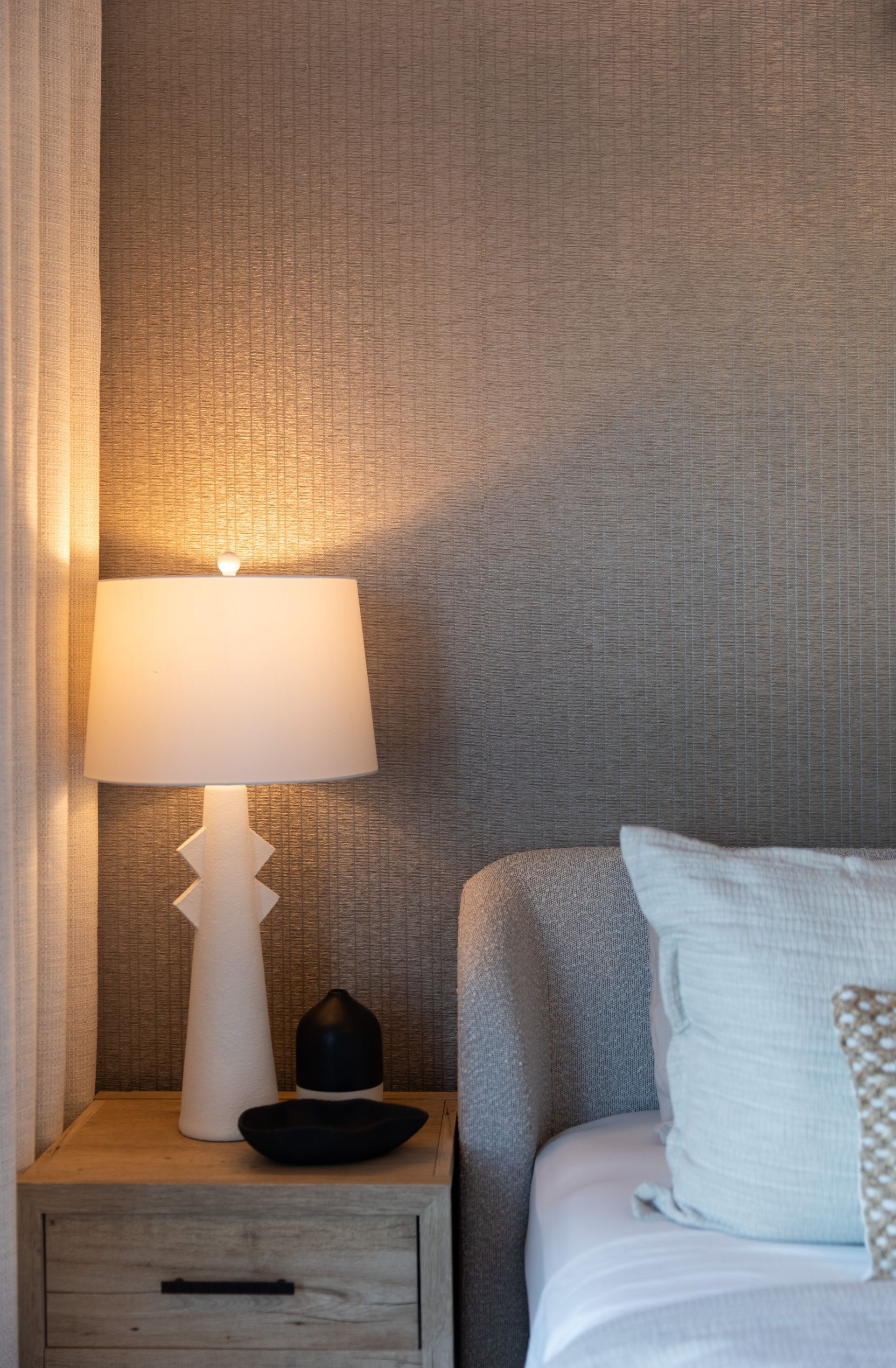 There is a lamp on the nightstand next to the bed.