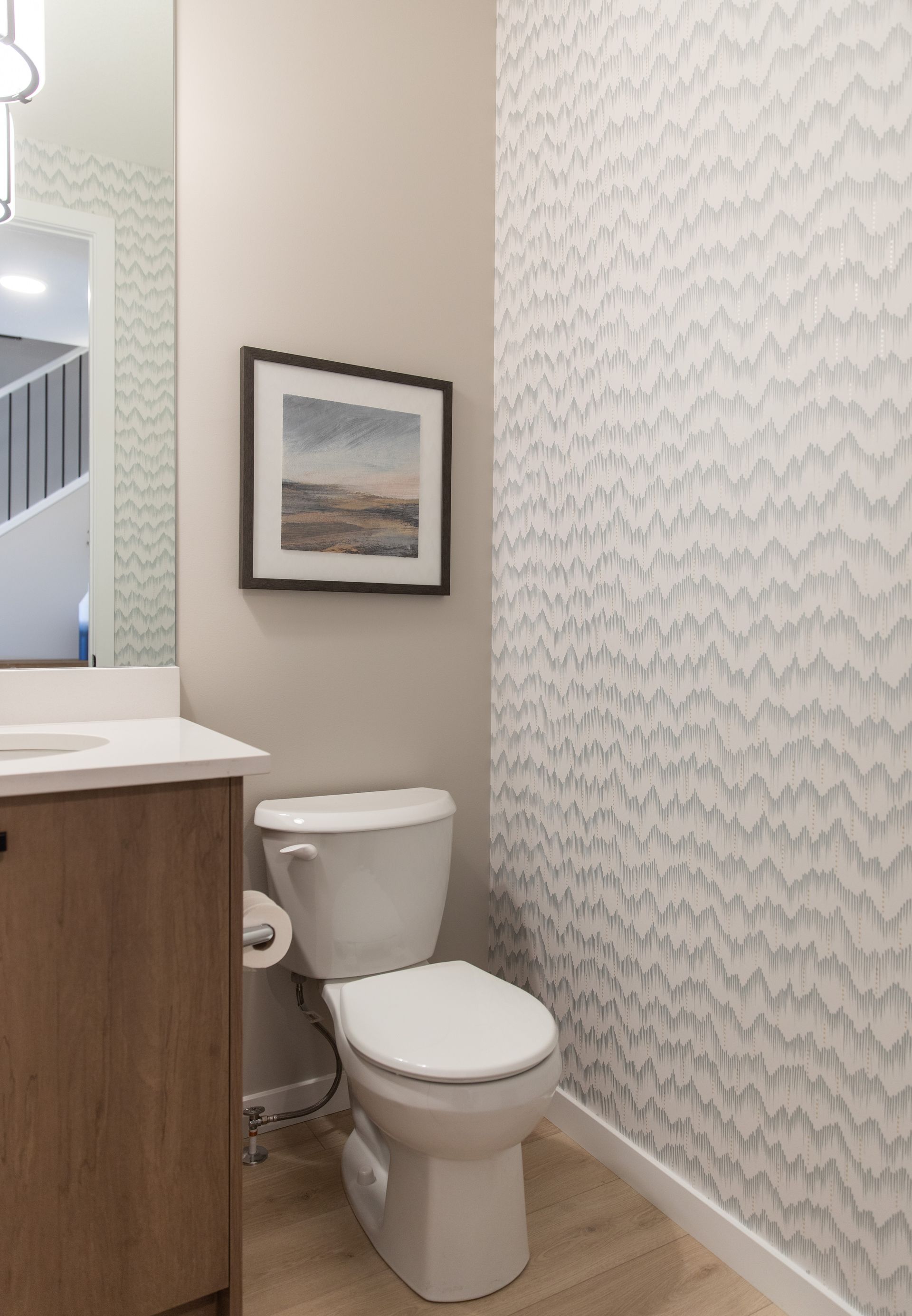 A bathroom with a toilet and a picture on the wall