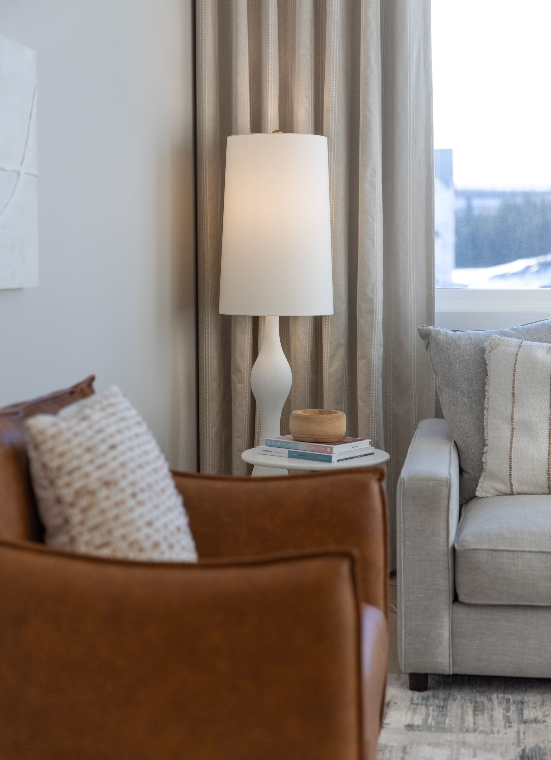 A living room with a couch , chair and lamp