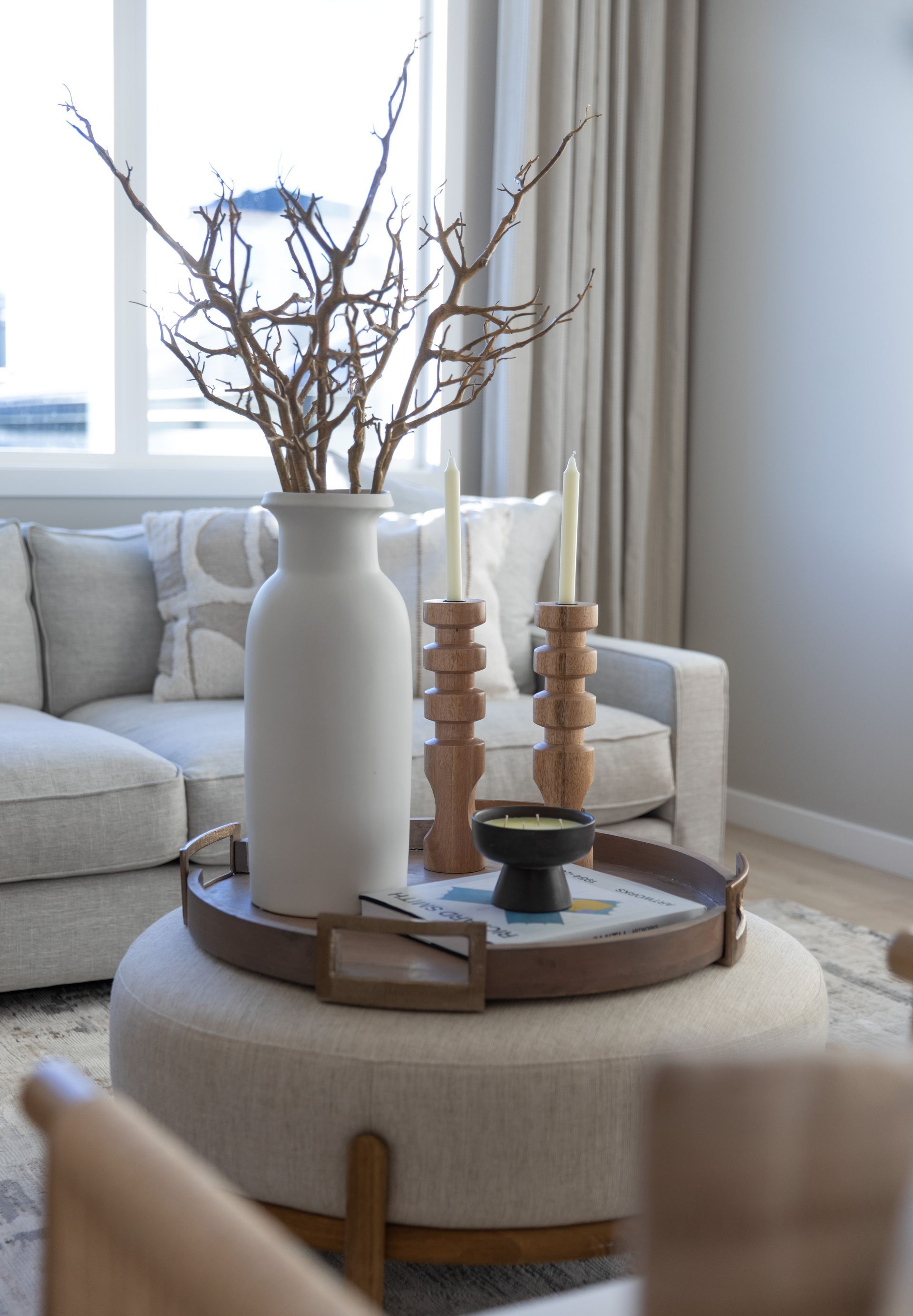 A living room with a couch and a coffee table with a vase on top of it.