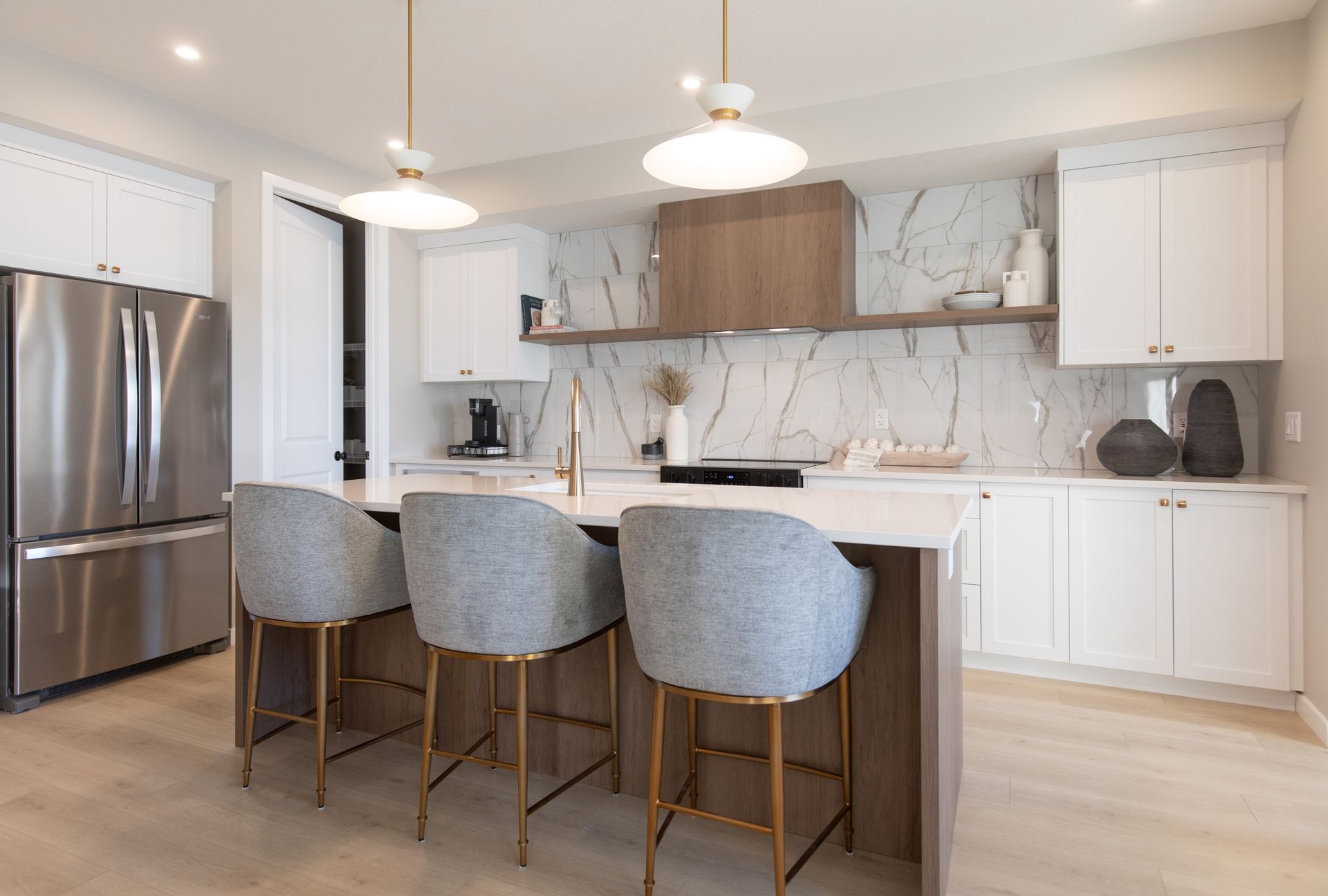 A kitchen with white cabinets , stainless steel appliances , and a large island.