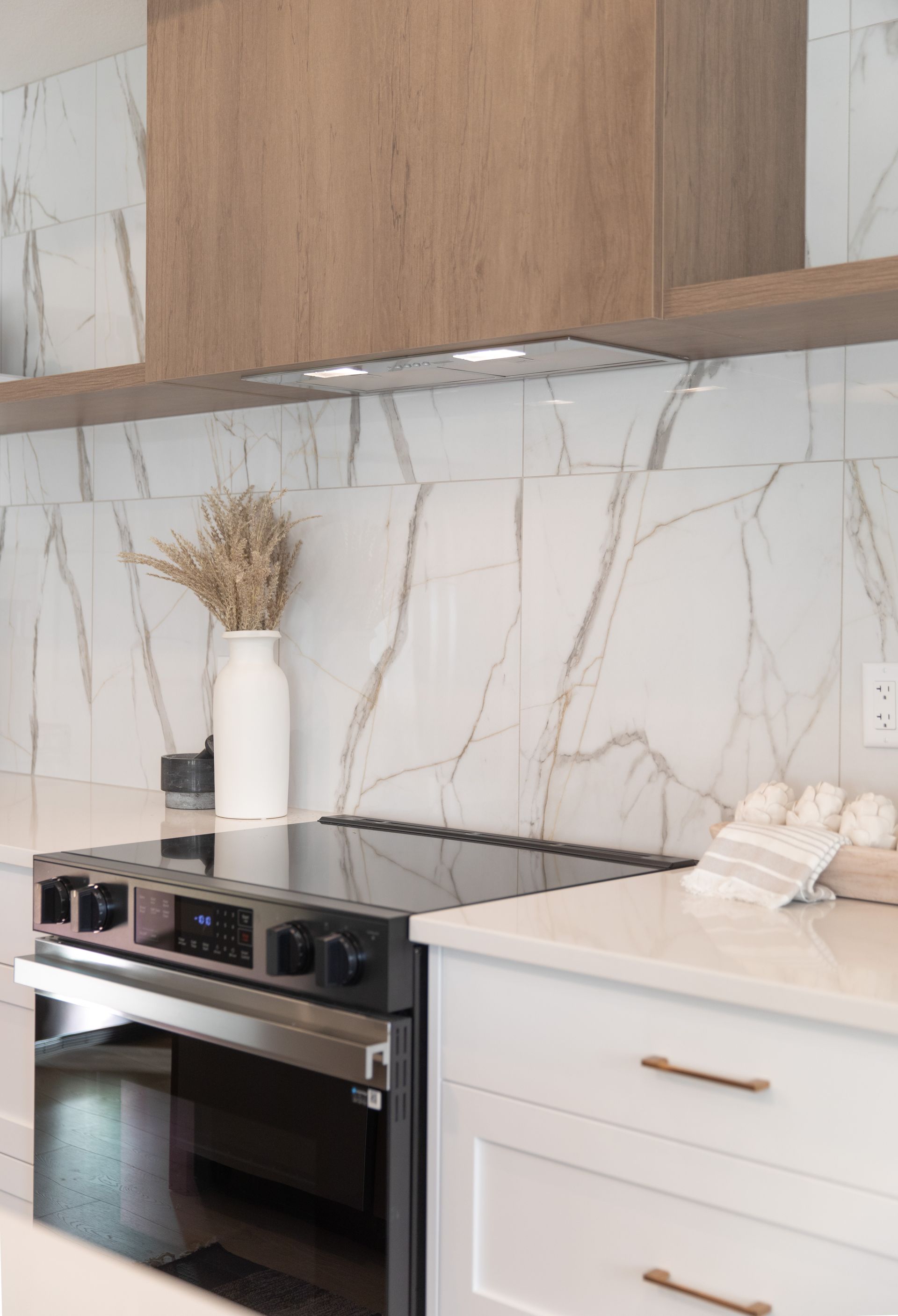 A kitchen with a stove top oven and white cabinets.