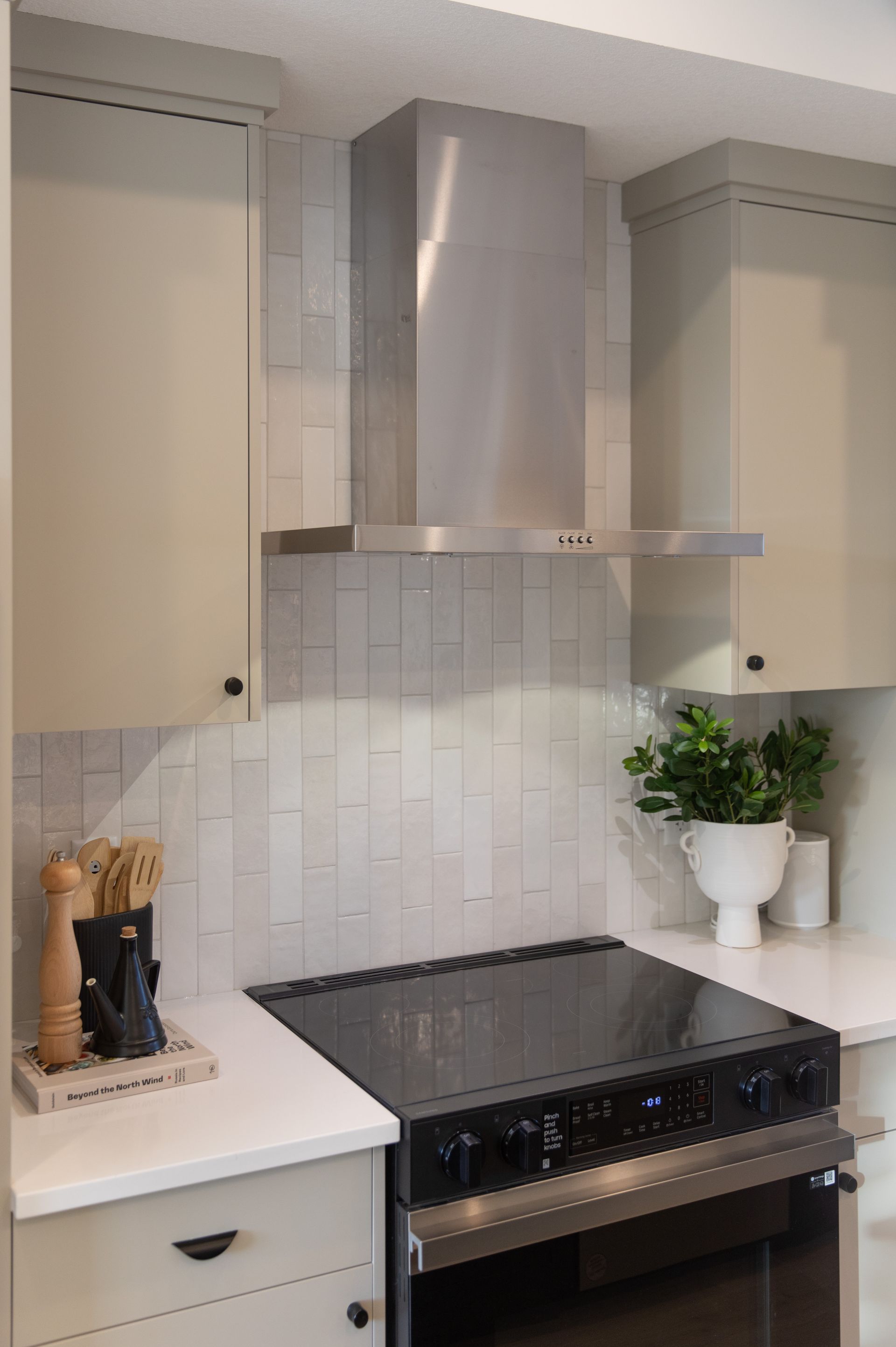 A kitchen with a stove top oven and a stainless steel hood.