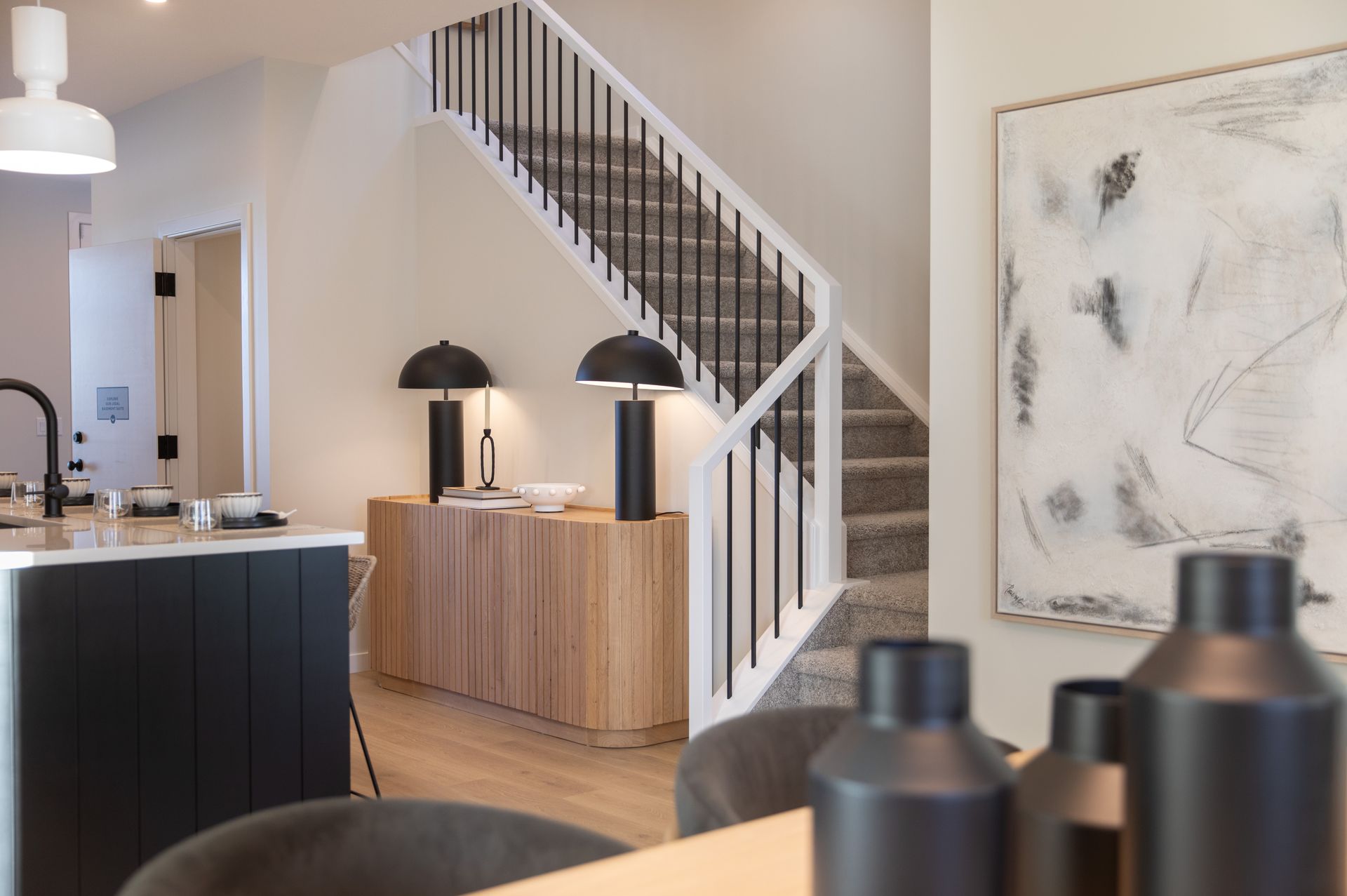 A kitchen with a staircase leading up to the second floor.