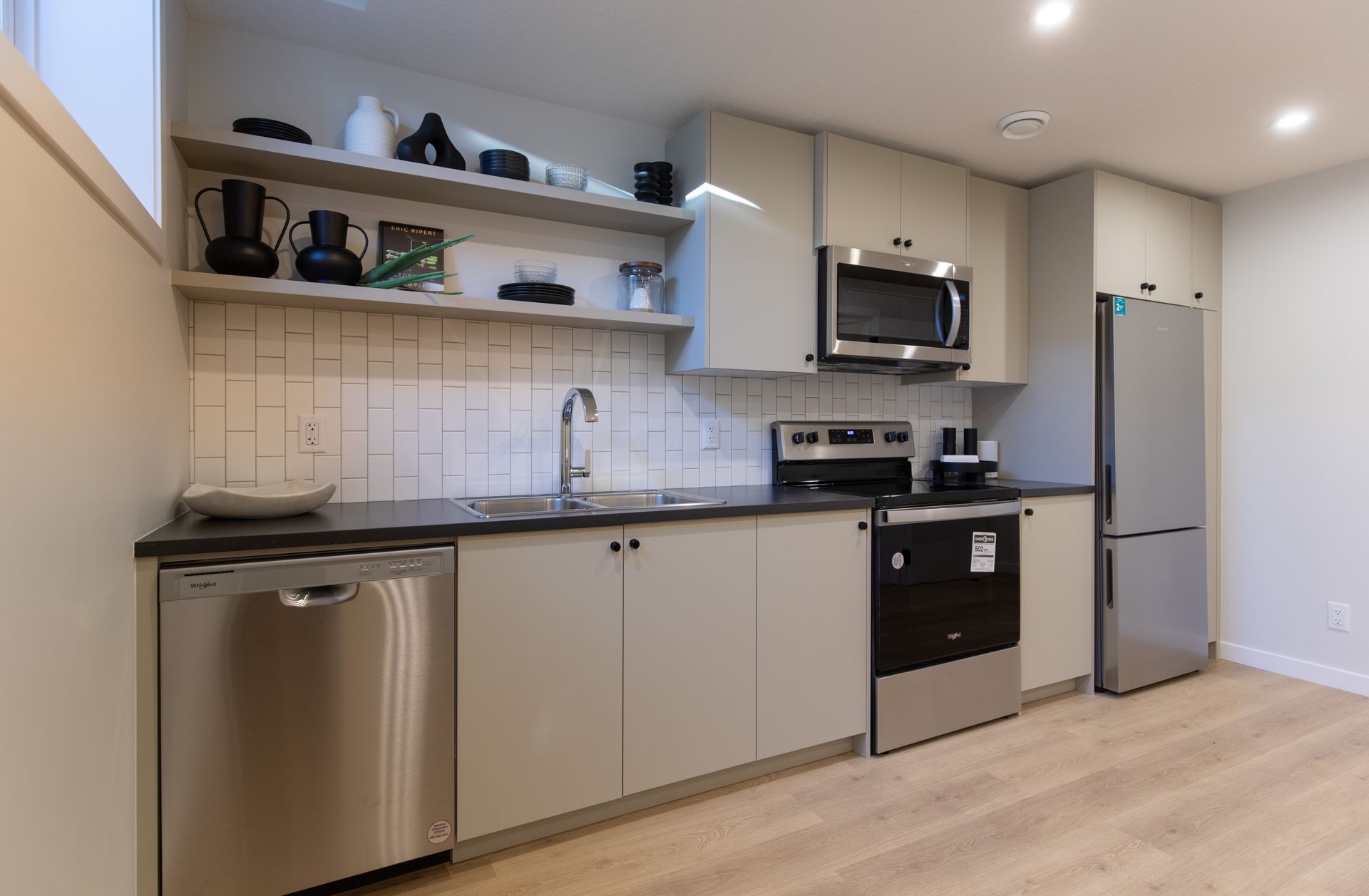 A kitchen with stainless steel appliances and white cabinets.