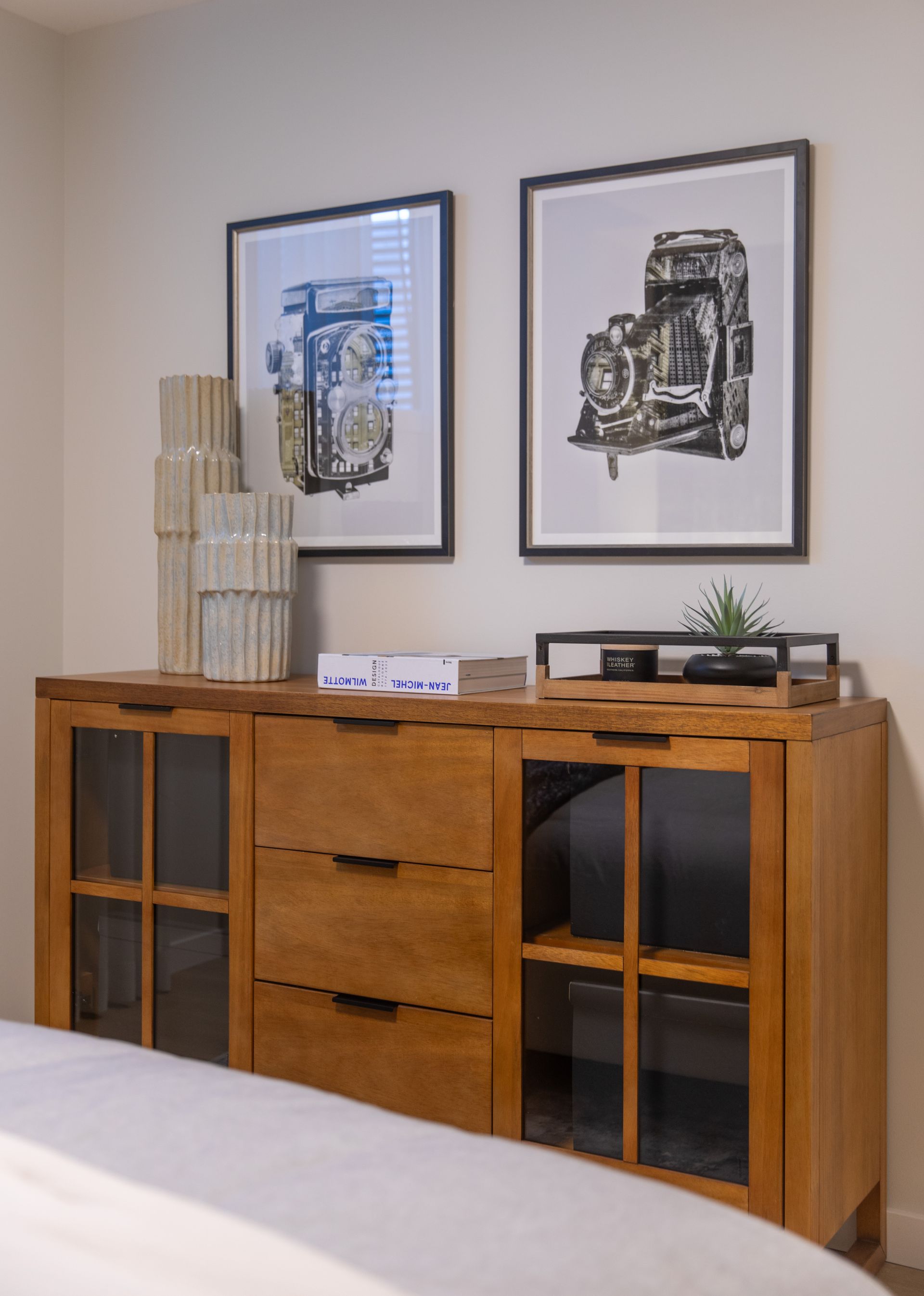A bedroom with a dresser and two pictures on the wall