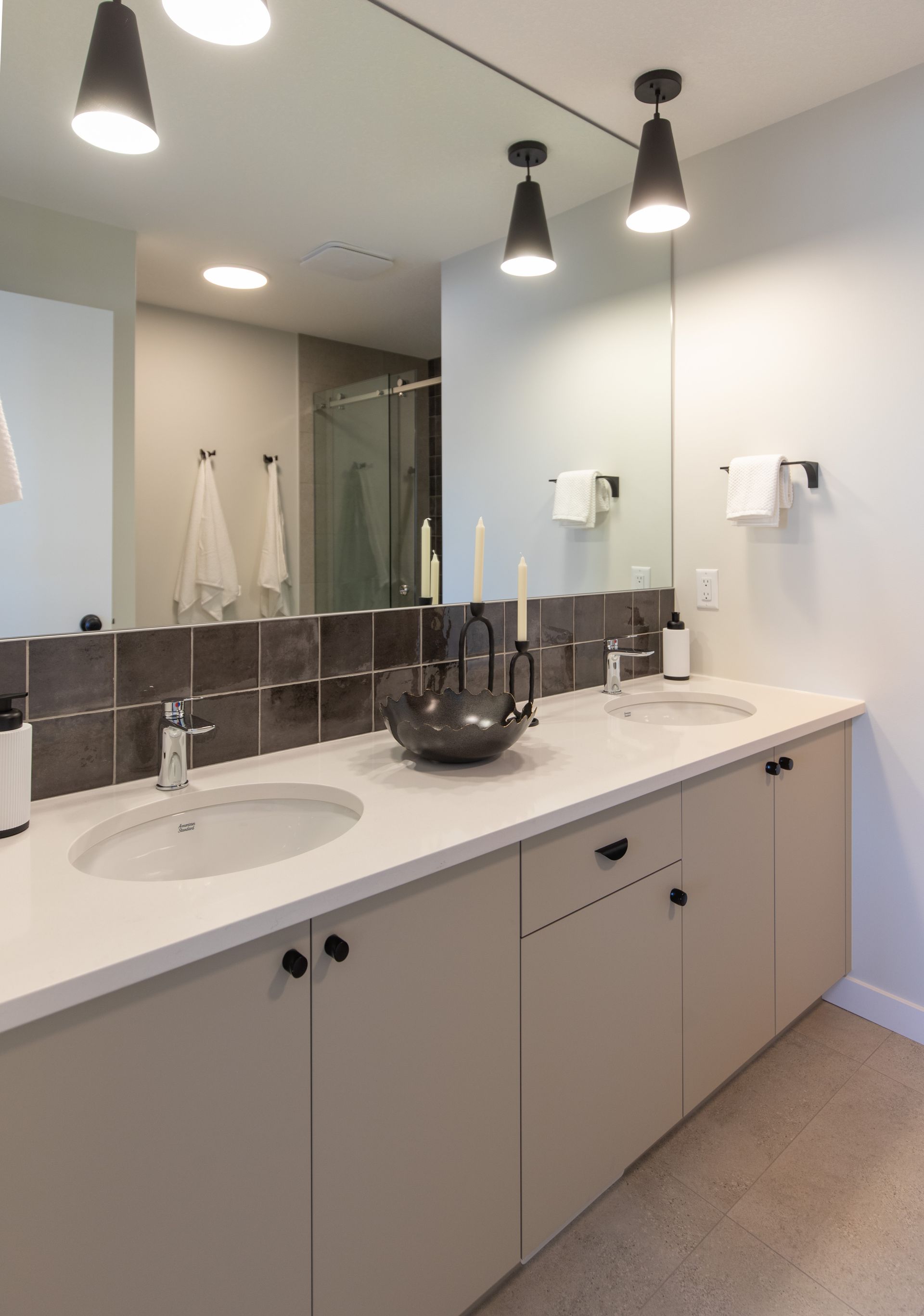 A bathroom with two sinks and a large mirror.