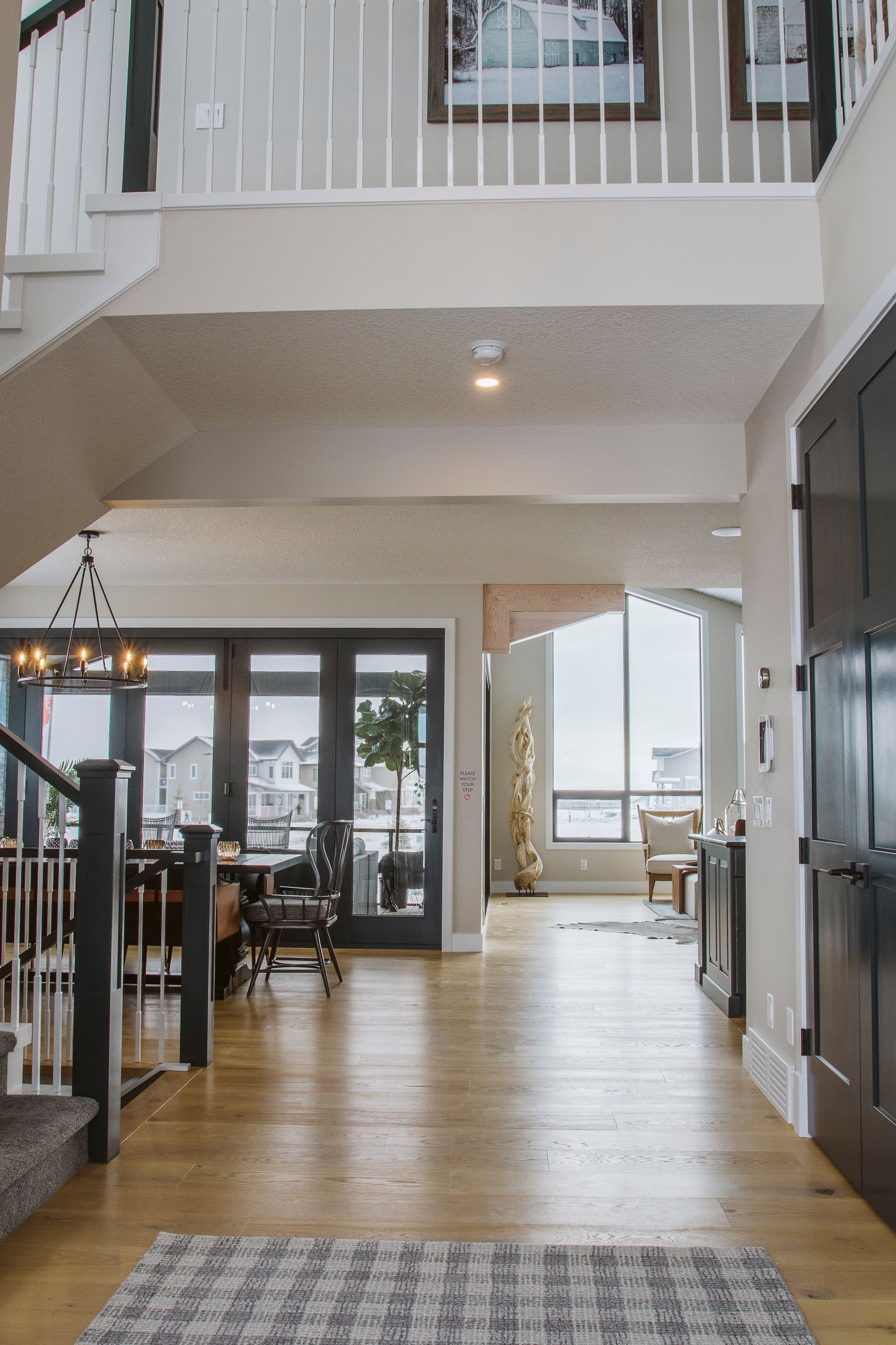 A hallway in a house with hardwood floors and stairs