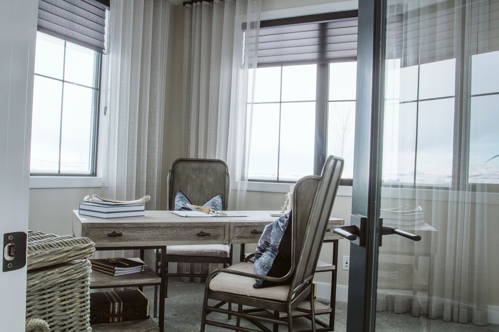 A home office with a desk , chair , and window.