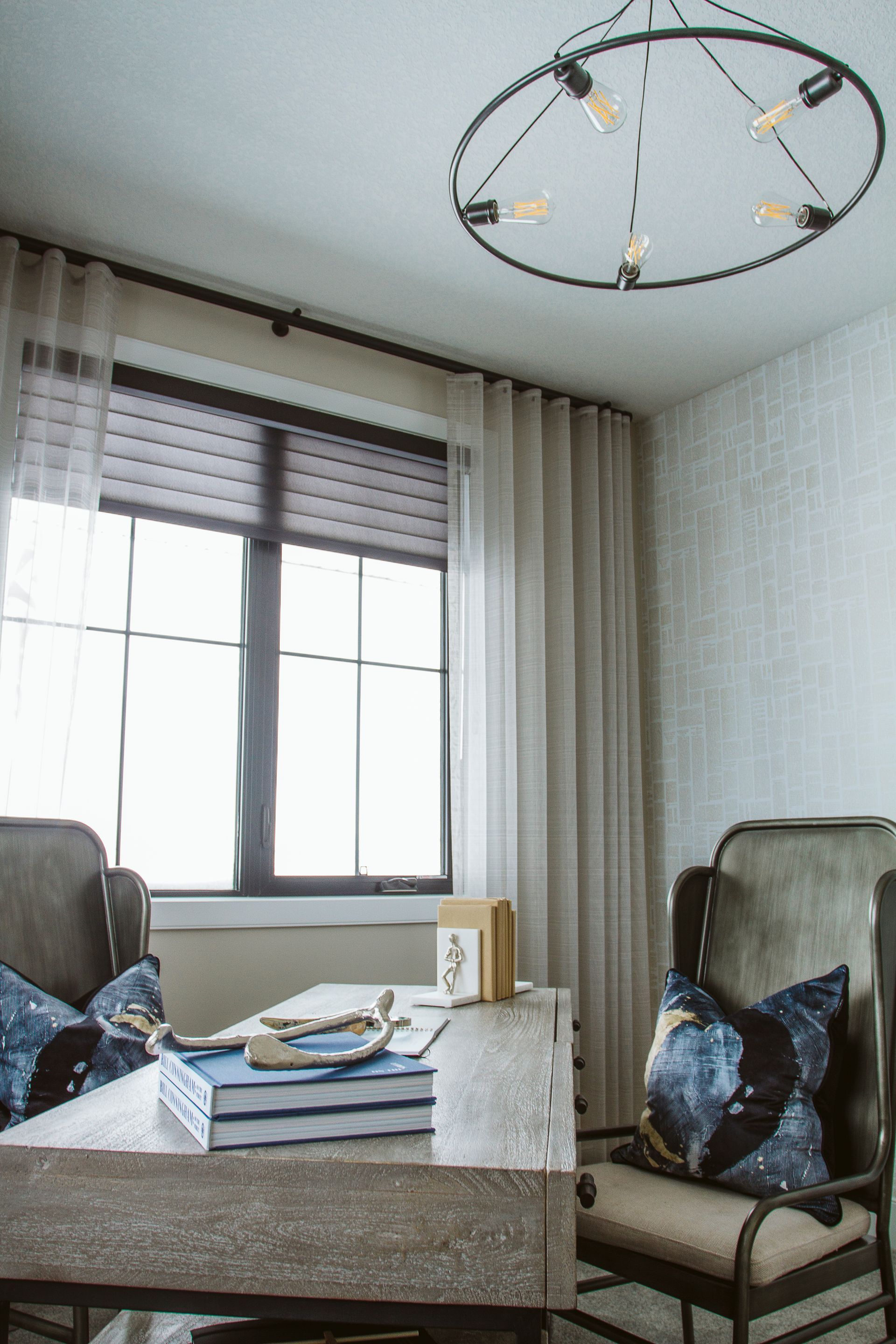 A living room with a table , chairs , and a chandelier.
