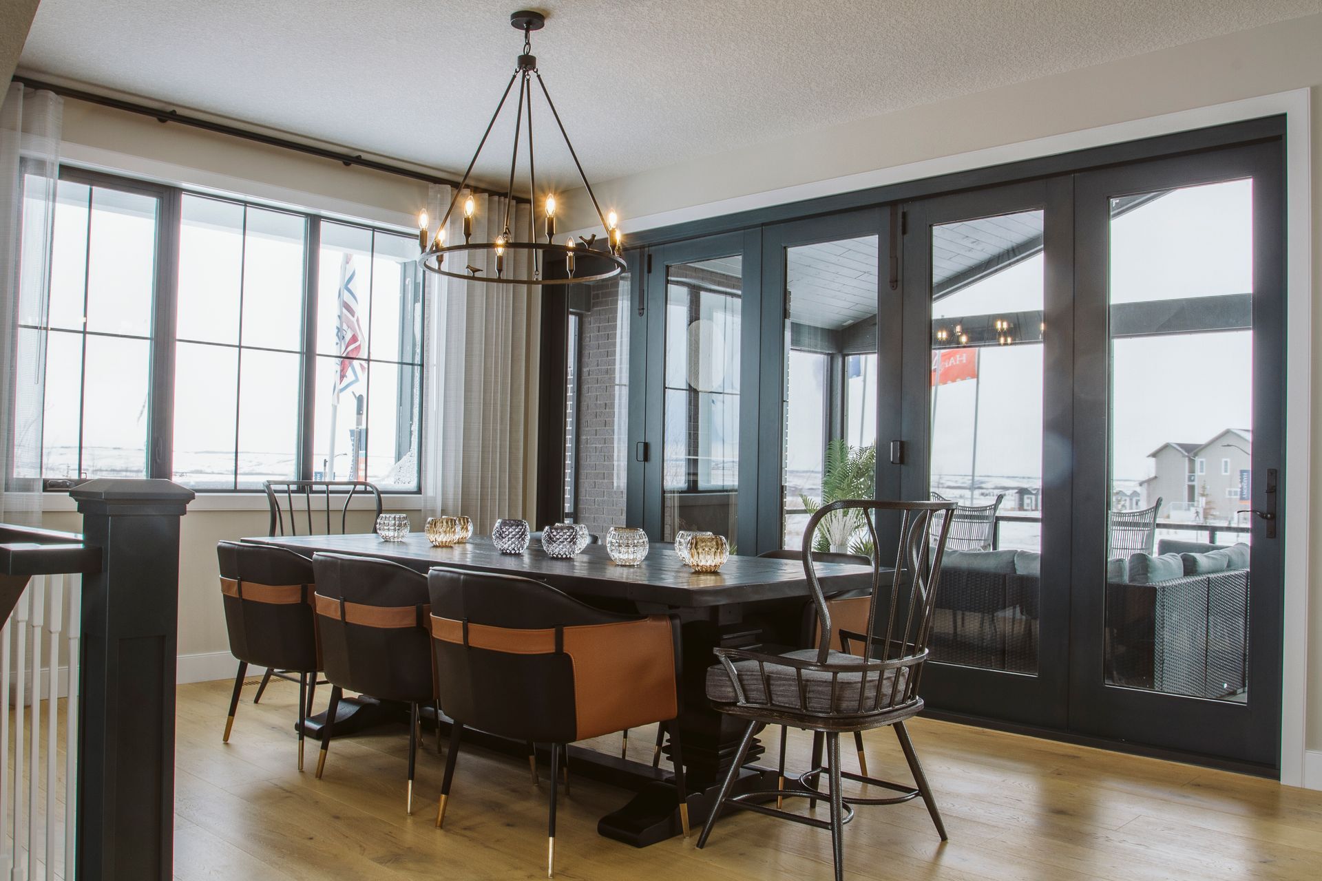 A dining room with a long table and chairs and a chandelier hanging from the ceiling.