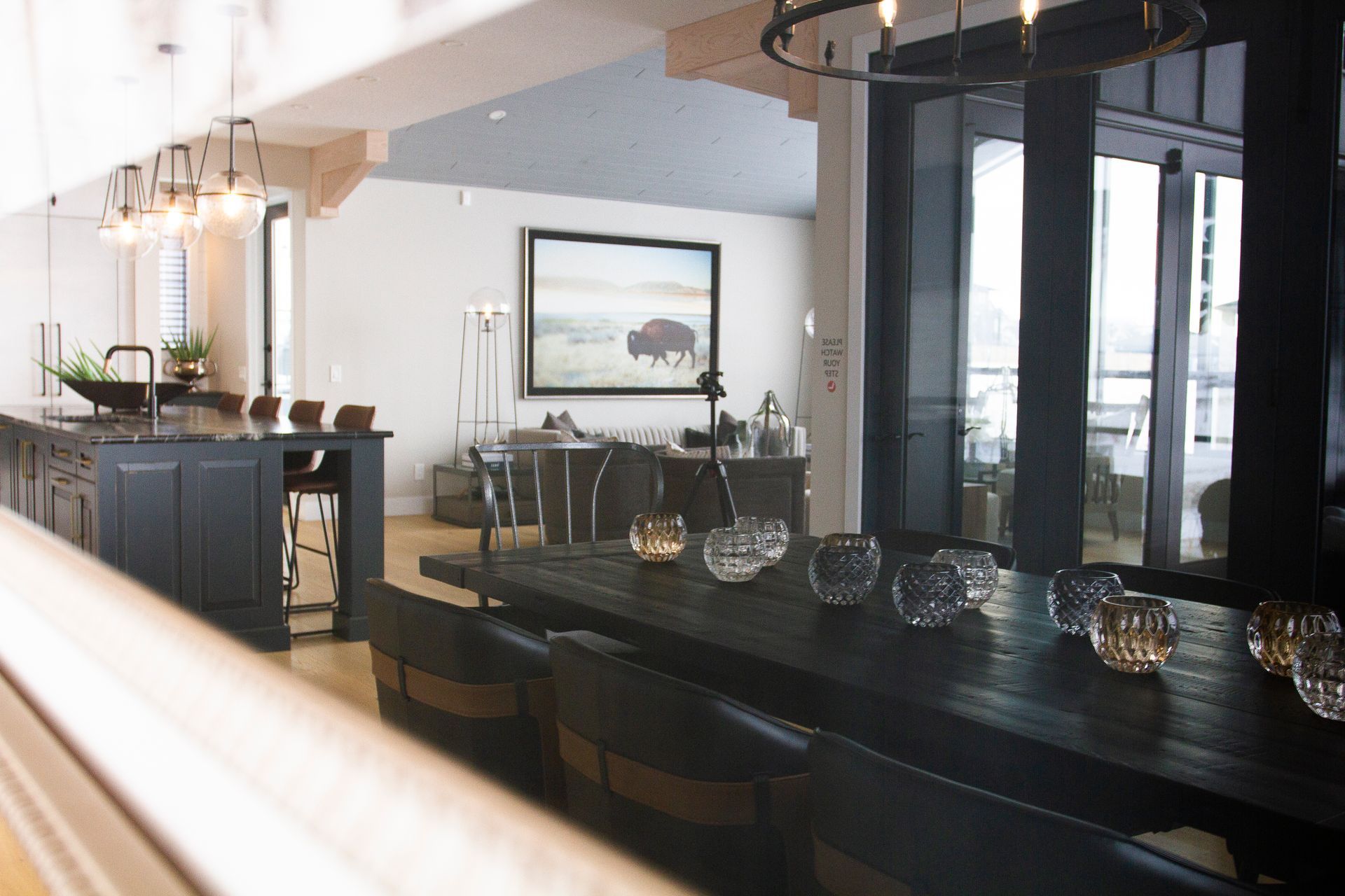 A large dining room table with a picture of a bison on the wall