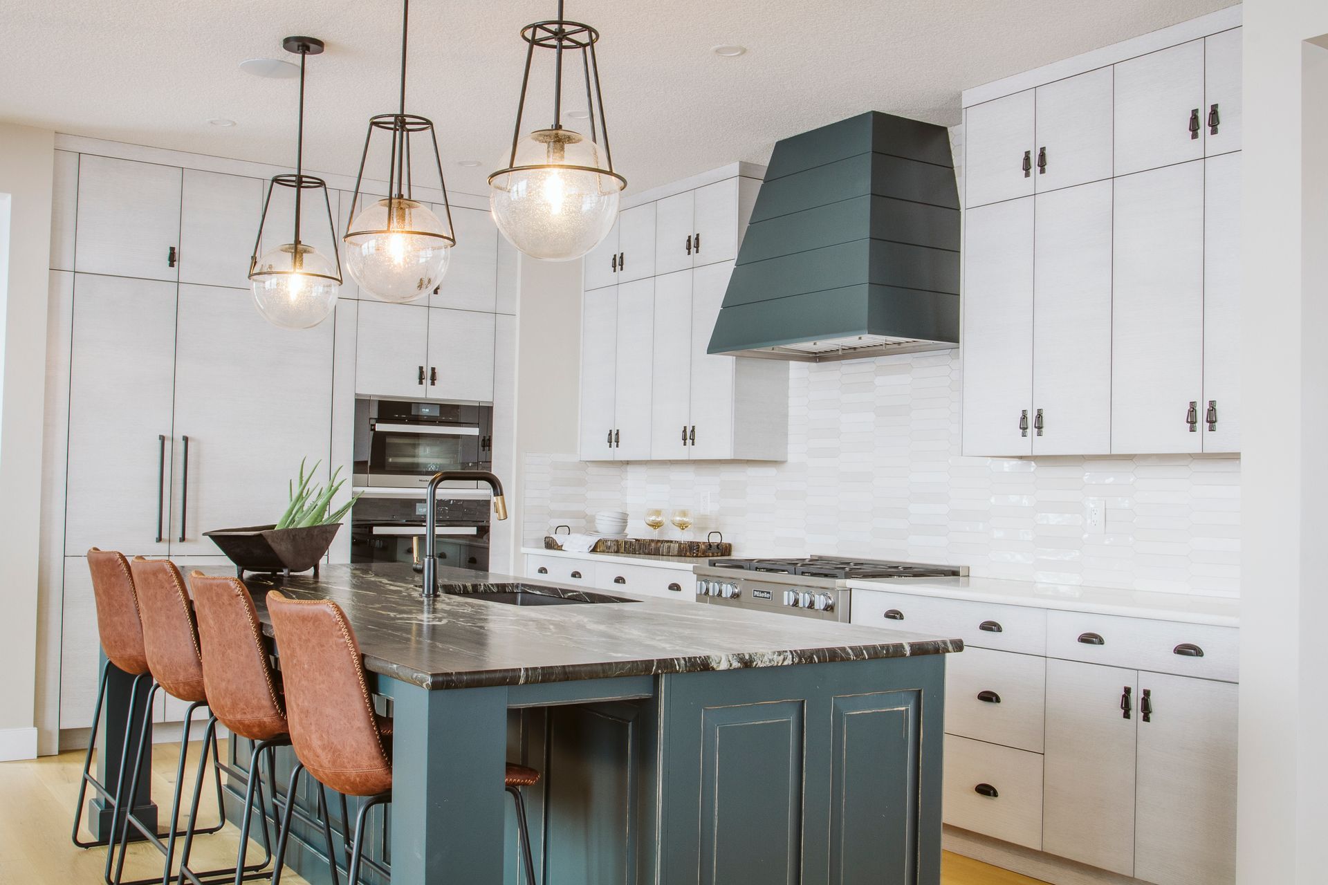 A kitchen with white cabinets and a blue island.