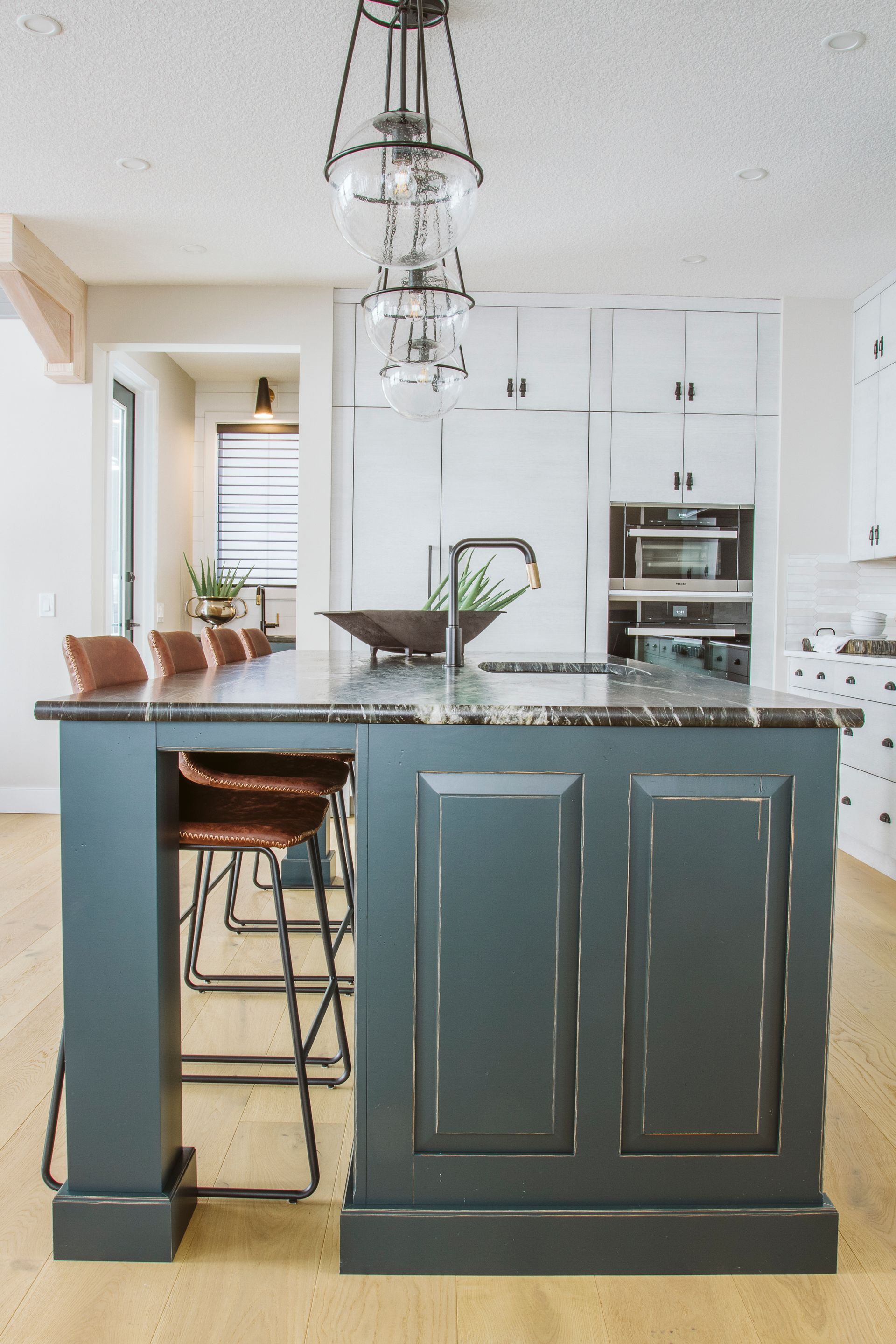 A kitchen with a large island and stools