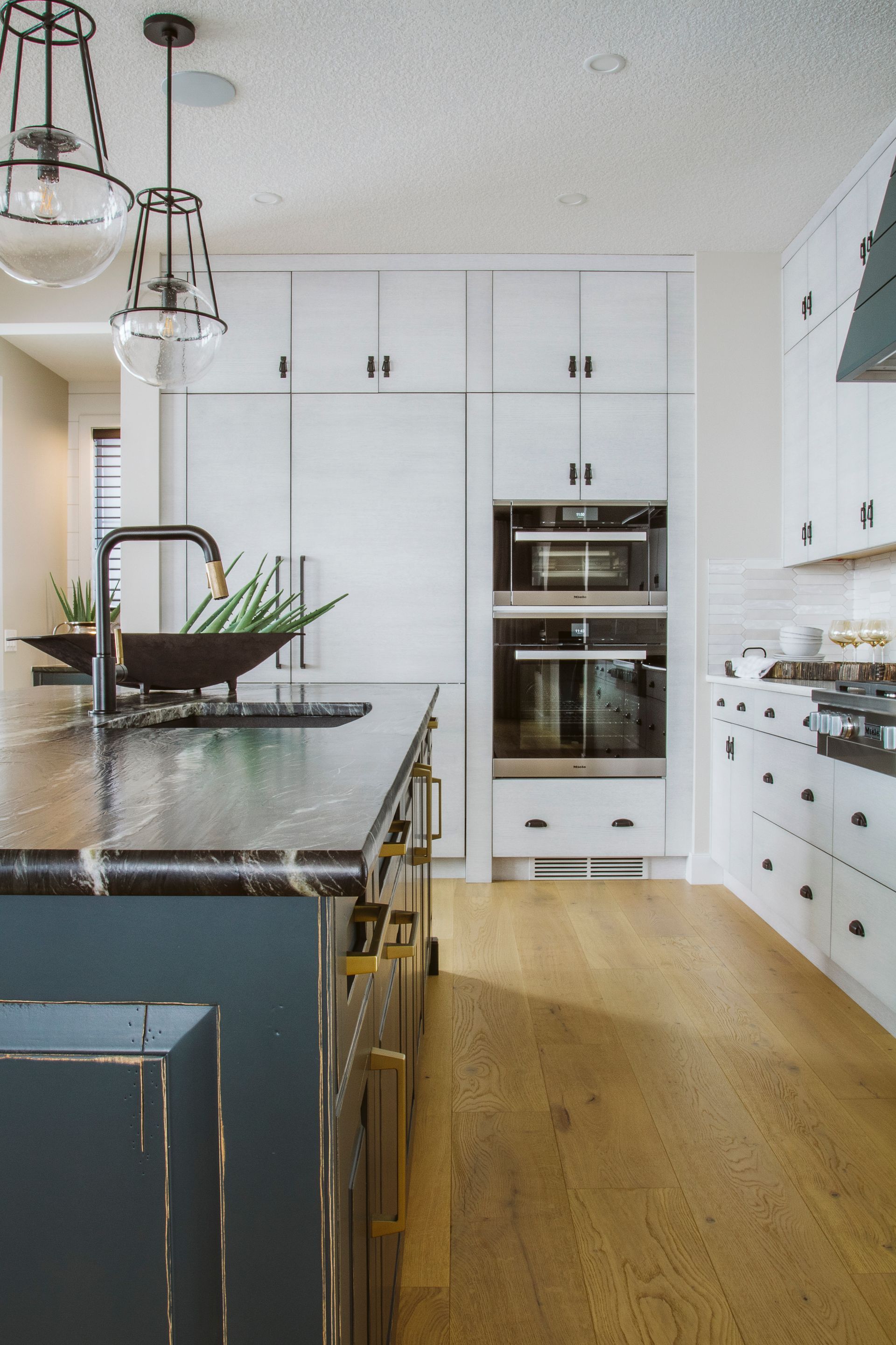 A kitchen with white cabinets and a black counter top