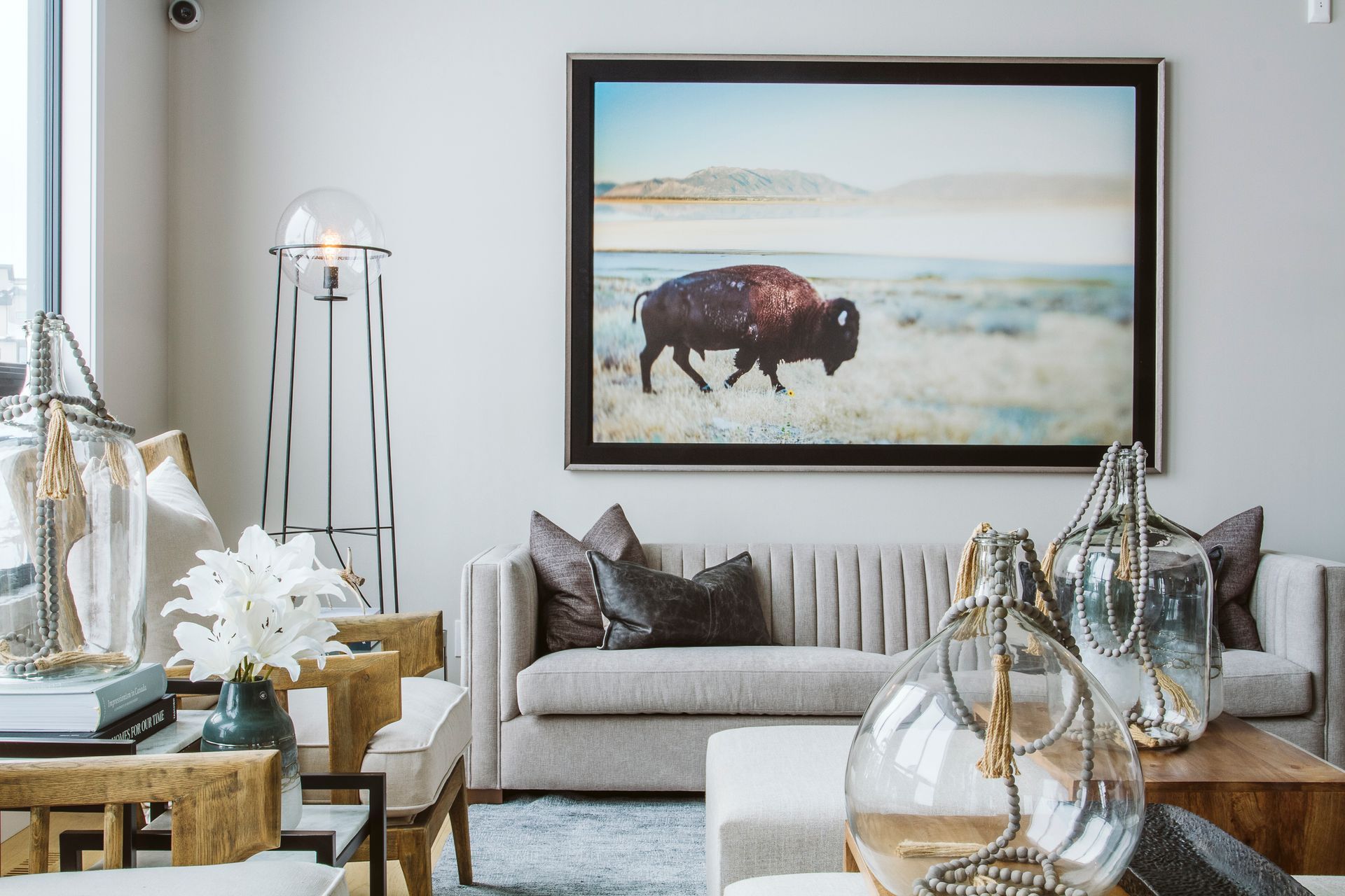 A living room with a couch and a picture of a bison on the wall.