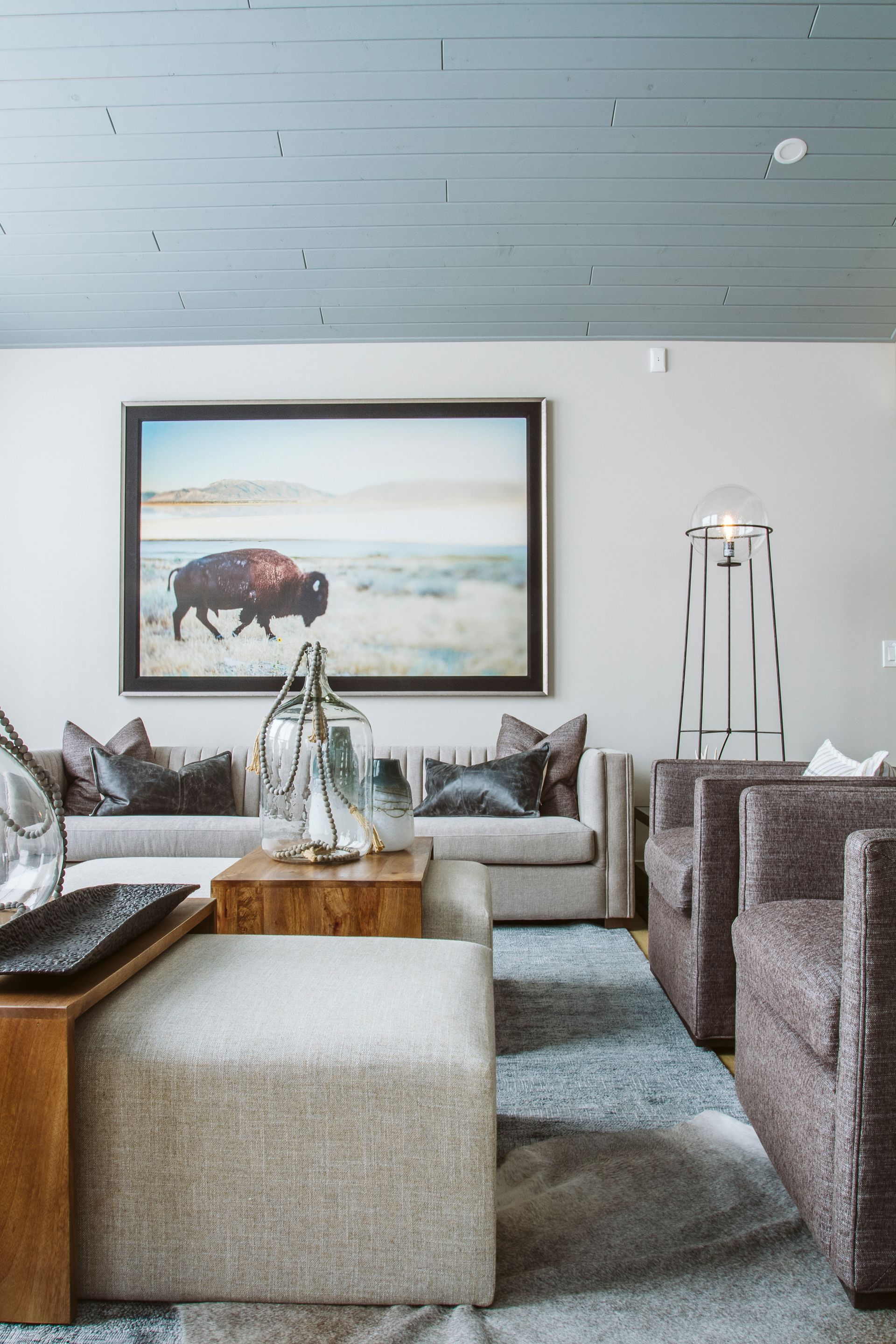 A living room with a painting of a bison on the wall