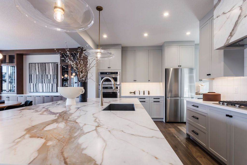 A kitchen with marble counter tops and stainless steel appliances.