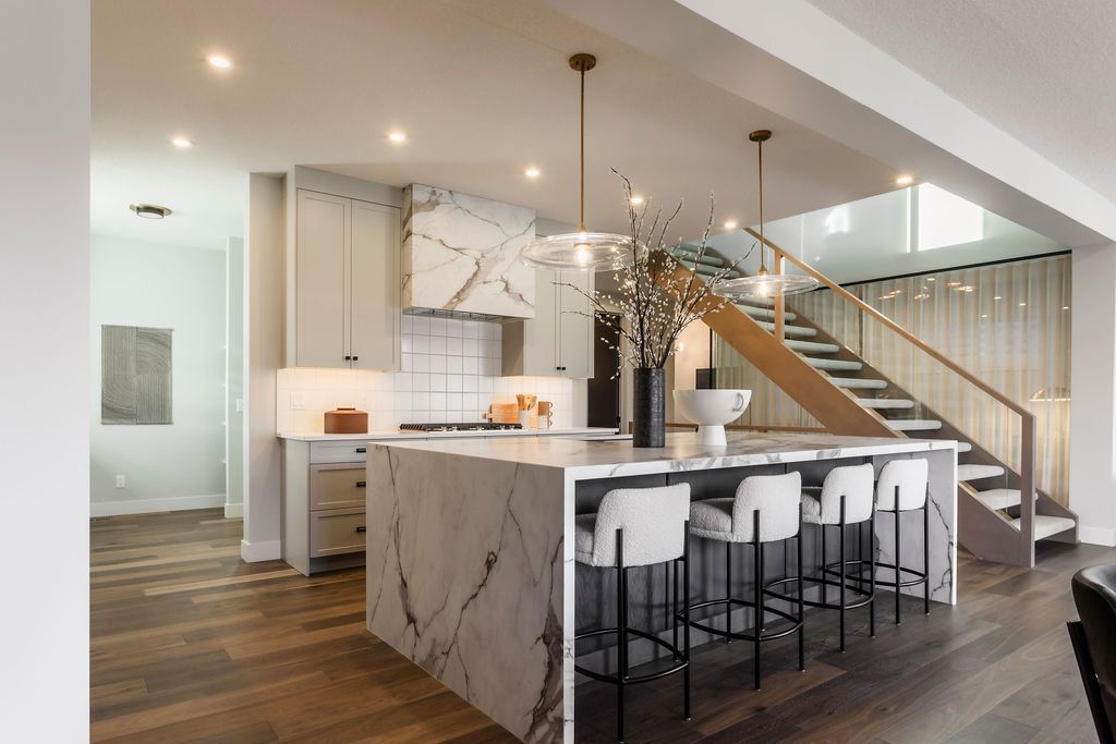 A kitchen with a large island and stairs leading to the second floor.