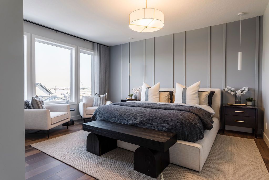 A bedroom with a large bed , a bench , a couch , and a lot of windows.