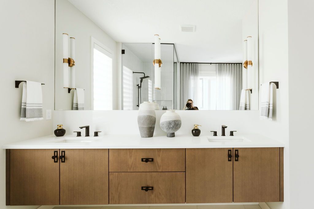 A bathroom with two sinks and a large mirror.