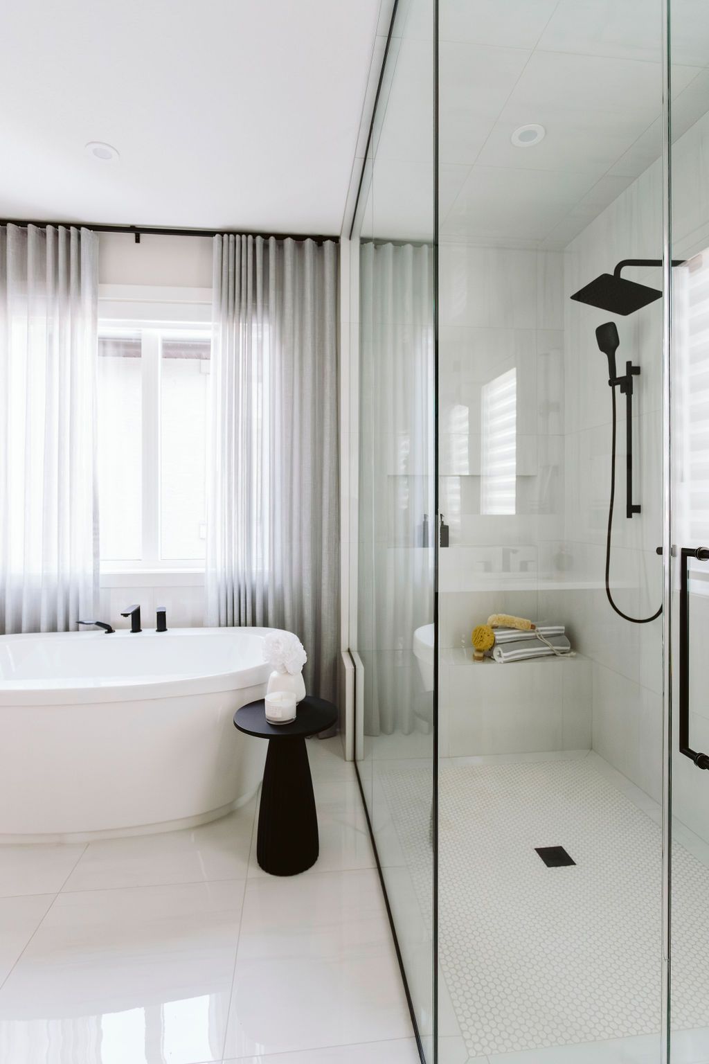 A bathroom with a bathtub , shower and window.