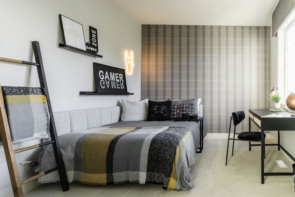 A bedroom with a bed , desk , chair and ladder.