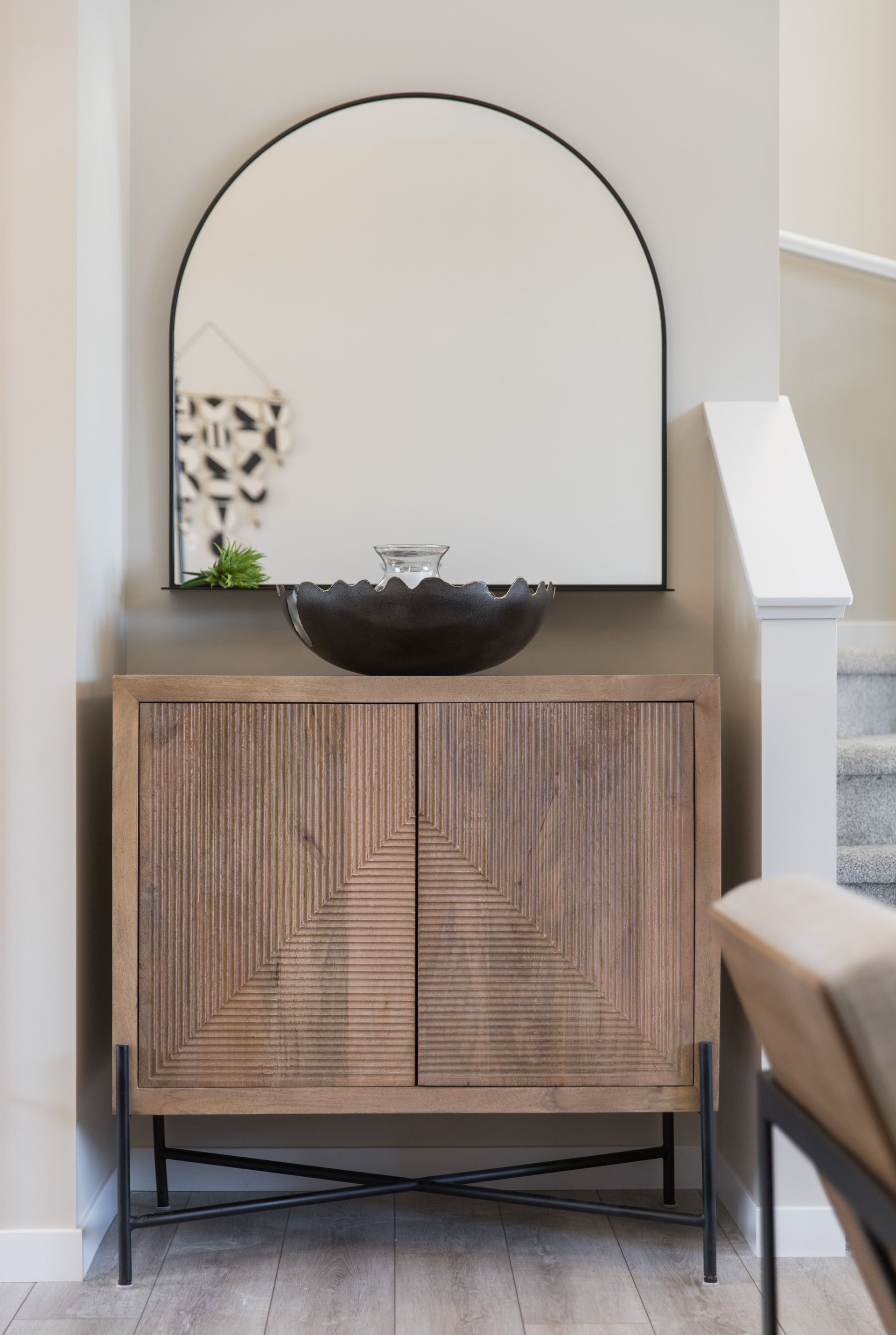 A wooden cabinet with a large mirror above it