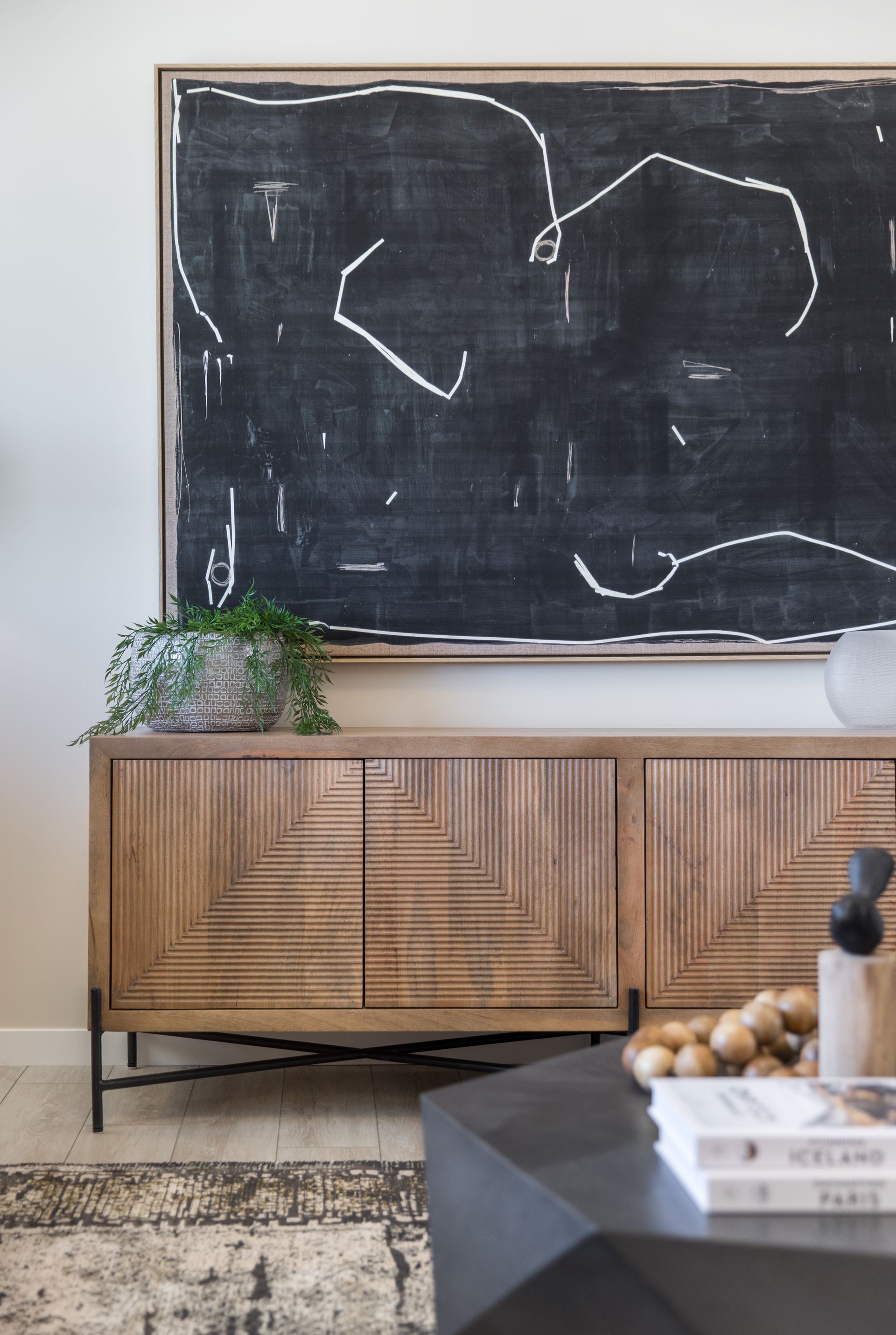 A living room with a chalkboard above a wooden cabinet