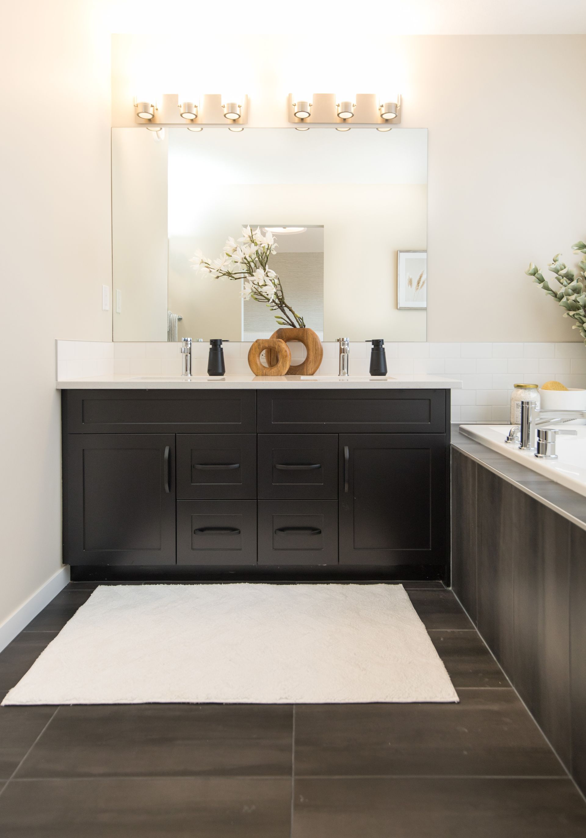 A bathroom with two sinks , a bathtub and a large mirror.