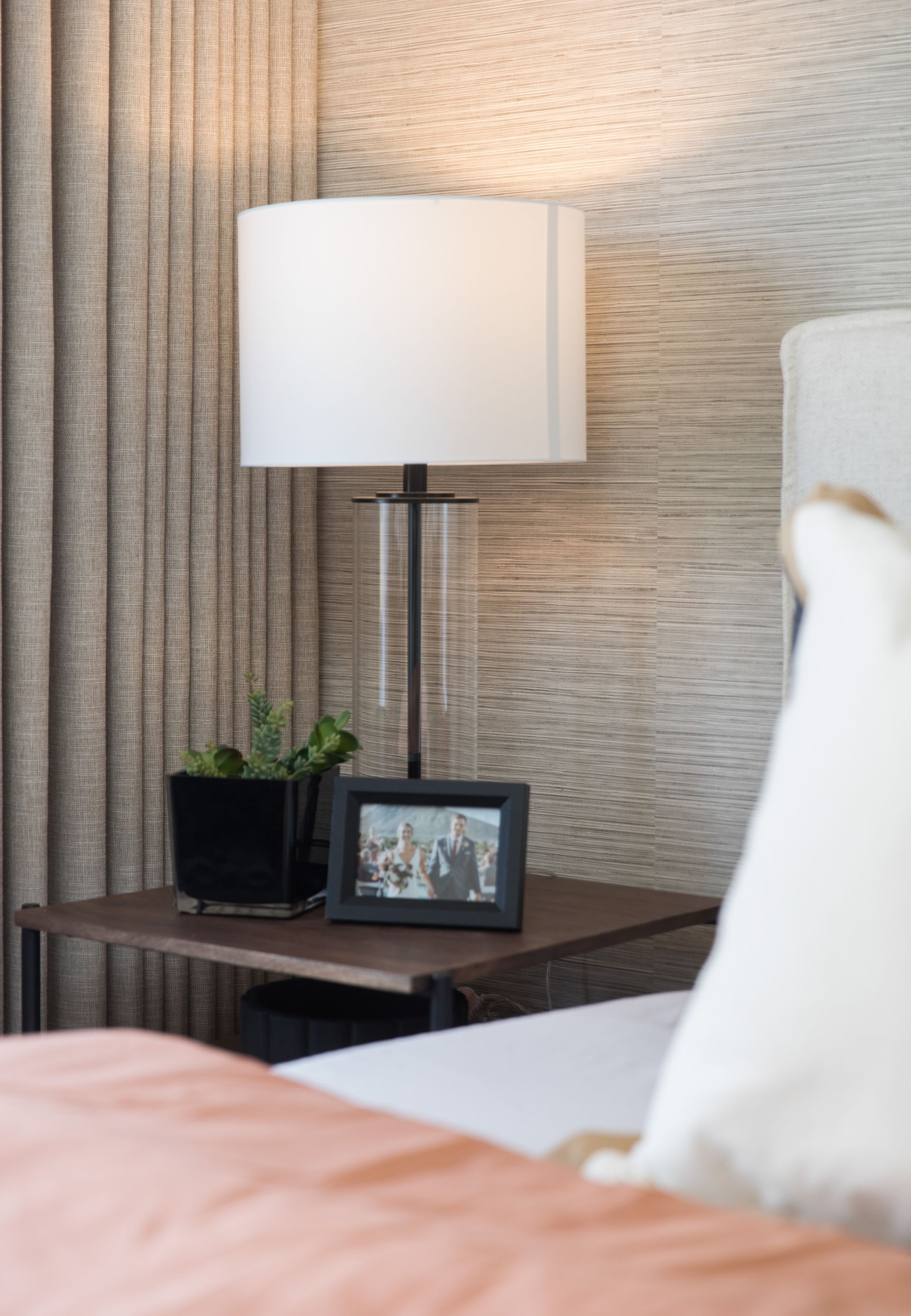 There is a picture frame on the nightstand next to the bed.