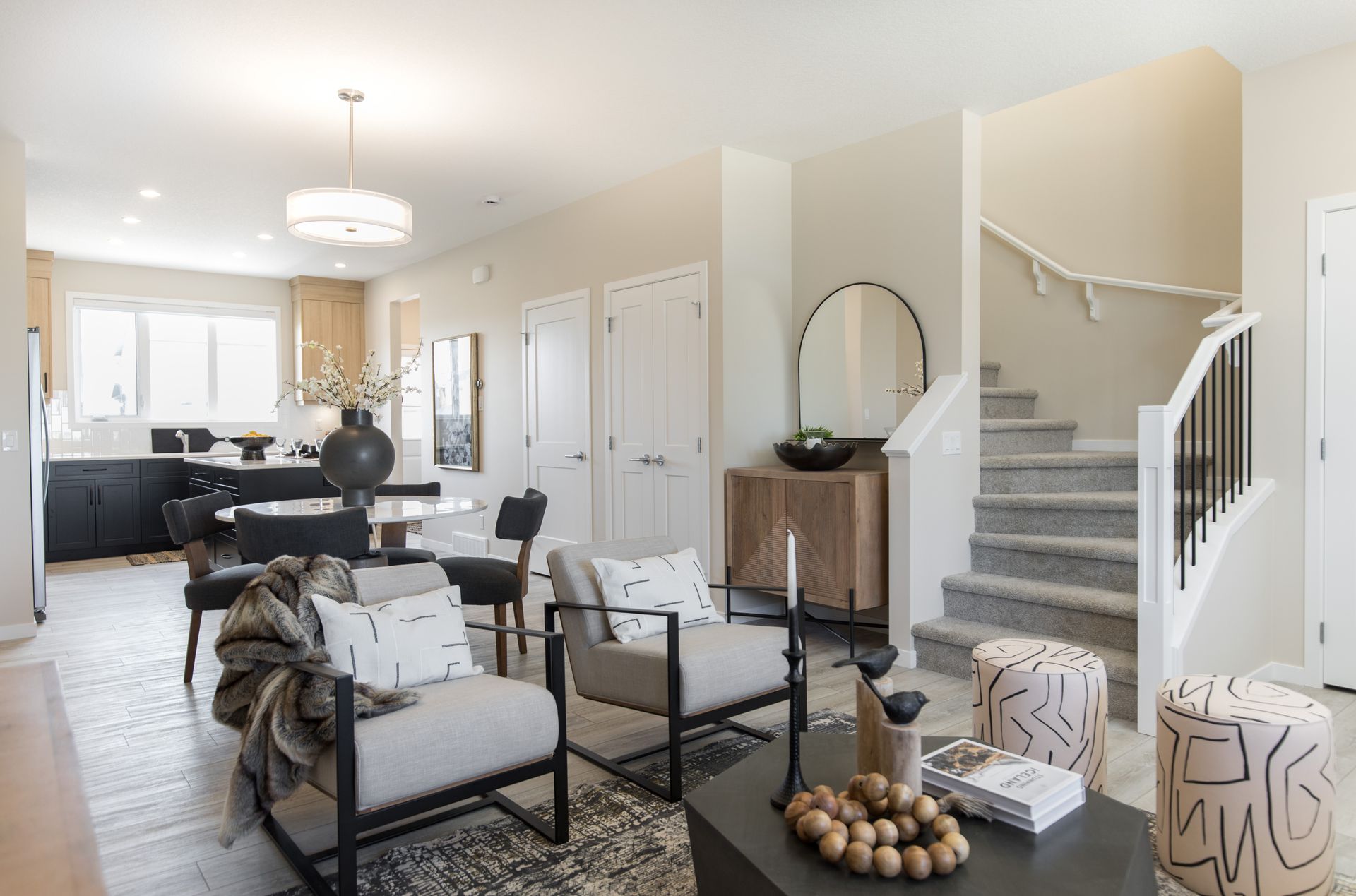A living room with chairs , a coffee table and stairs.