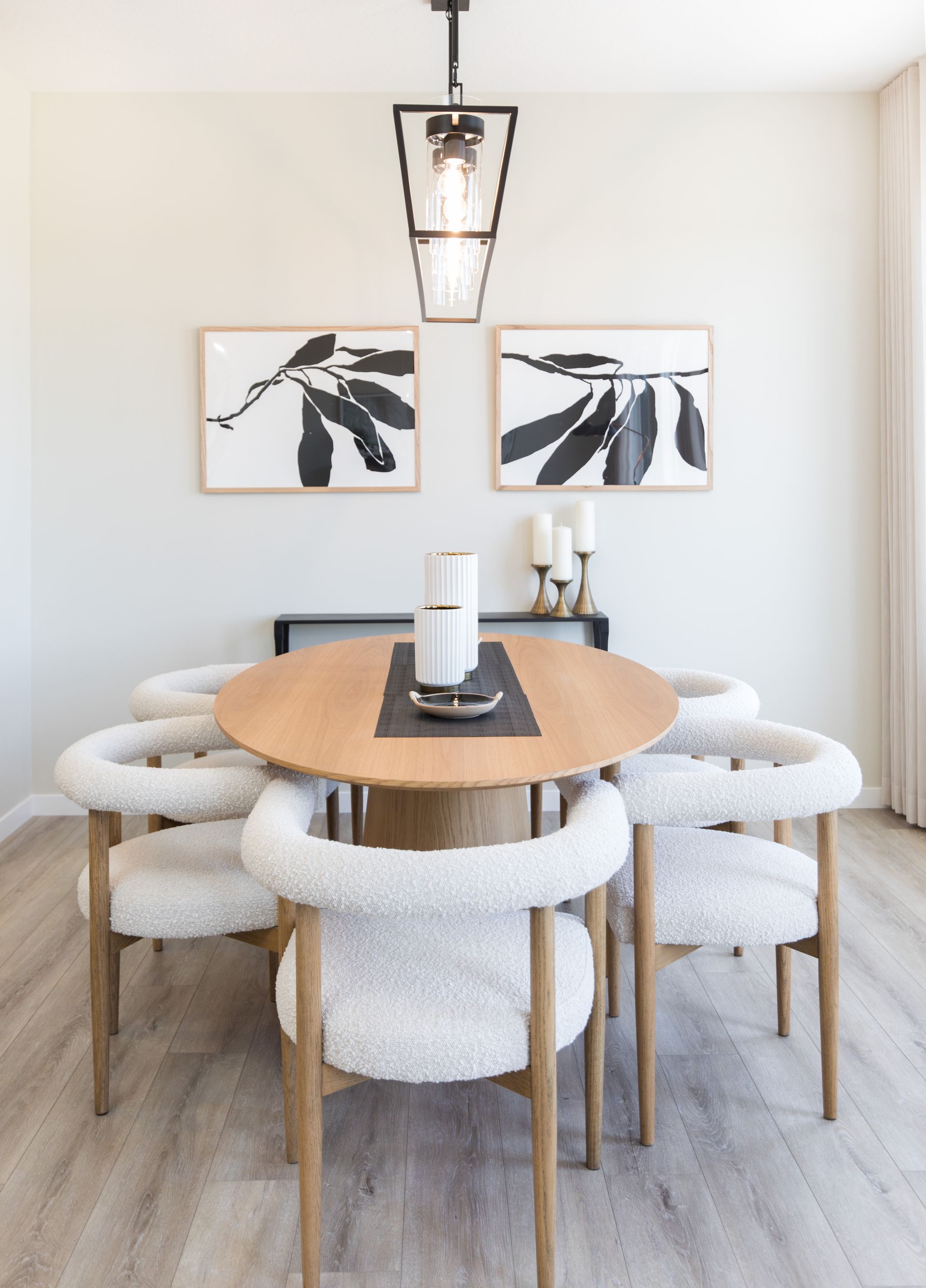 A dining room with a round table and white chairs