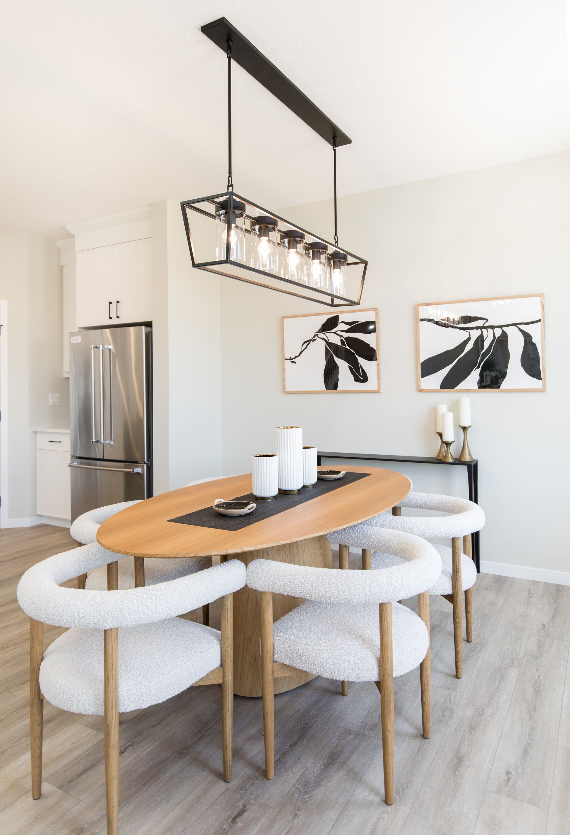 A dining room with a wooden table and white chairs