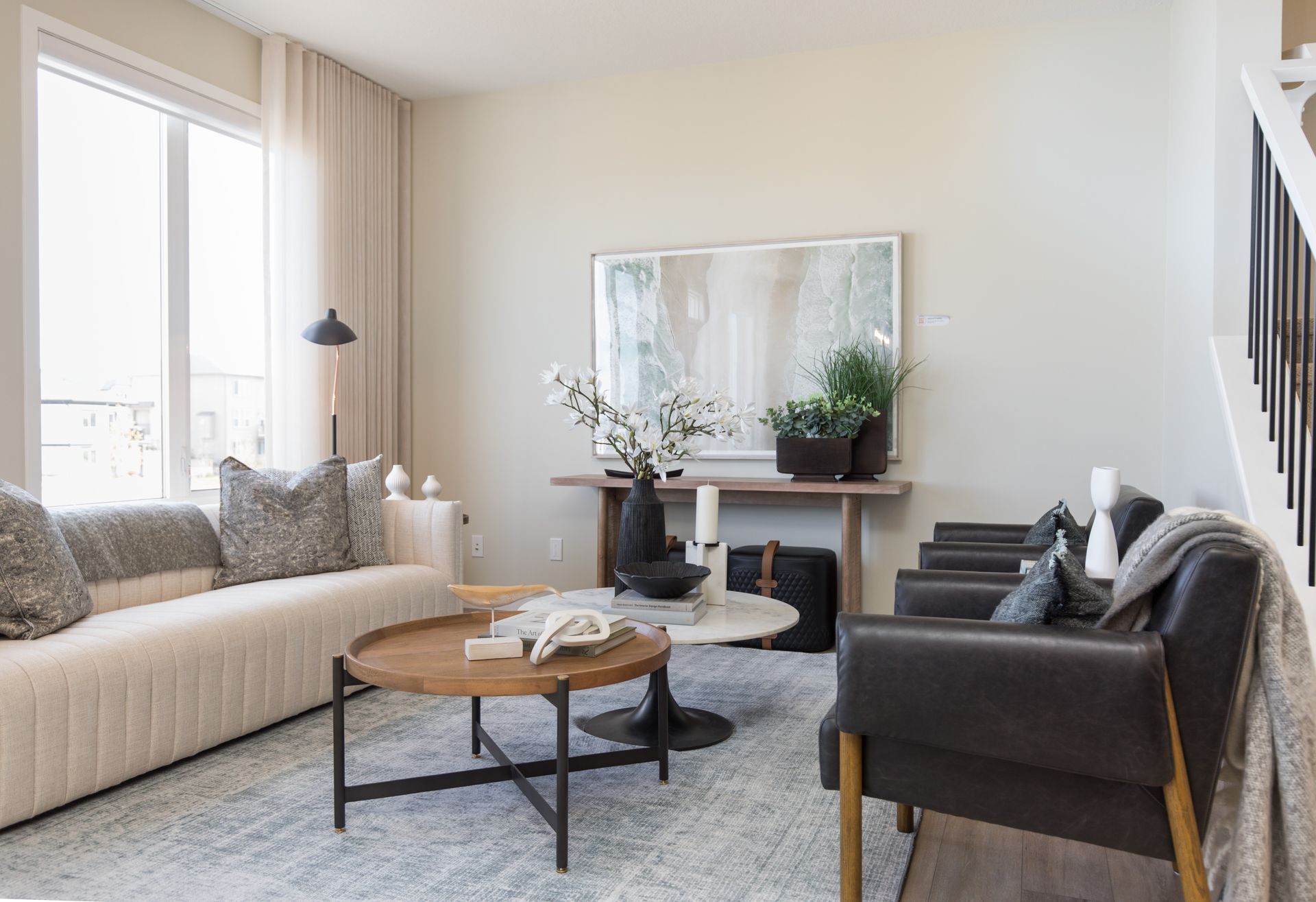 A living room with a couch , chair , coffee table and mirror.