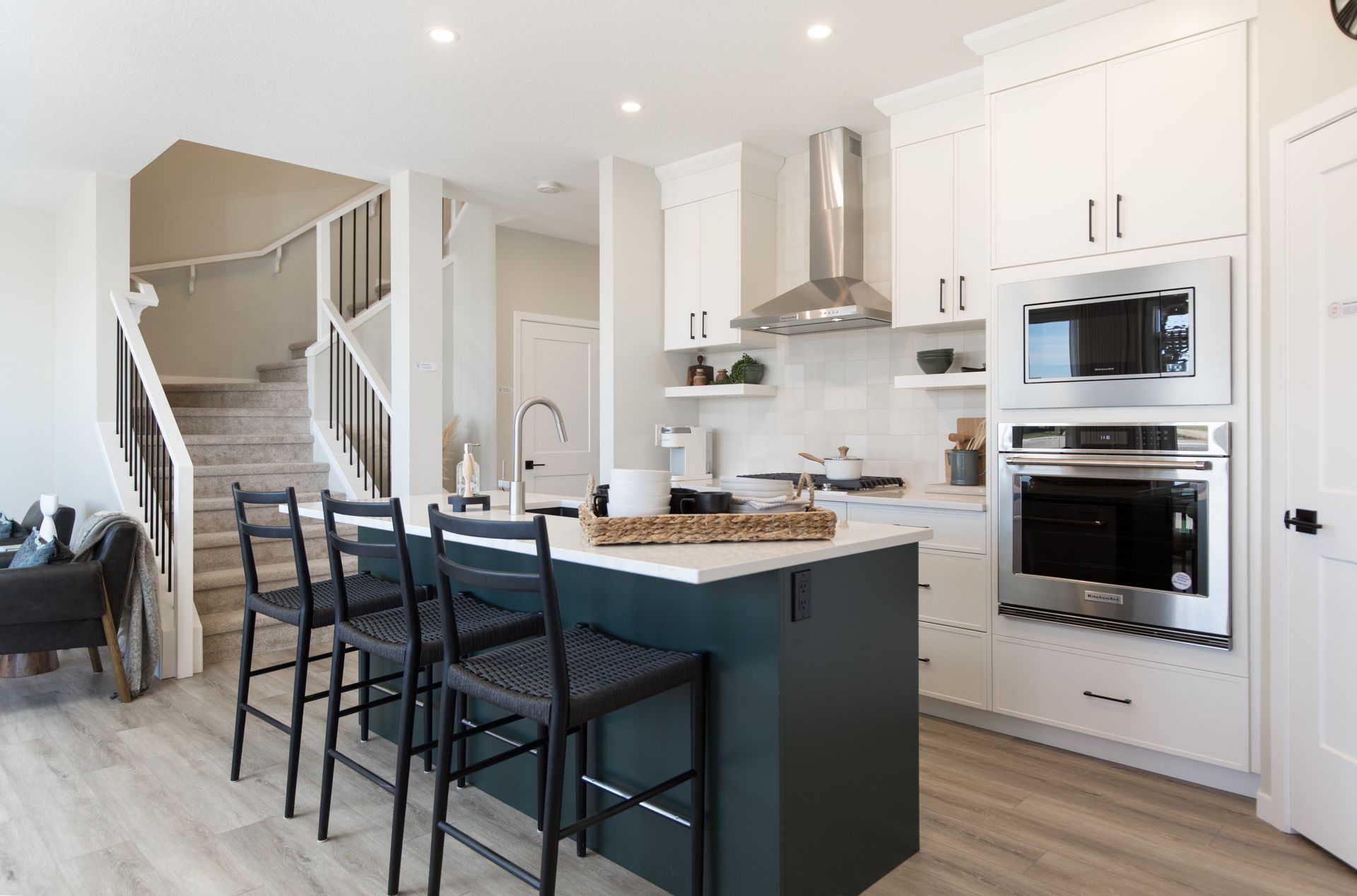 A kitchen with white cabinets and stainless steel appliances and a large island.