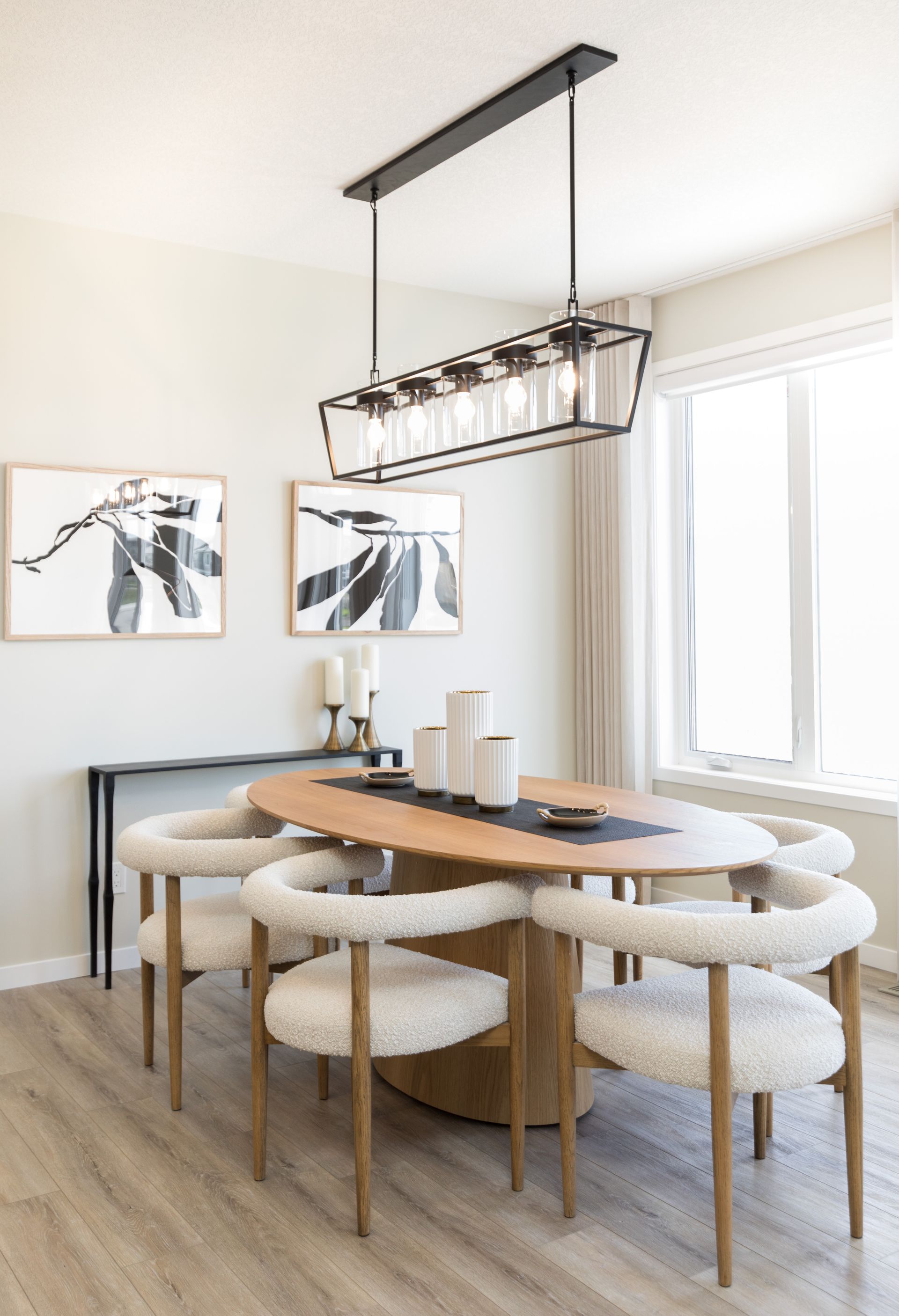 A dining room with a table and chairs and a chandelier hanging from the ceiling.