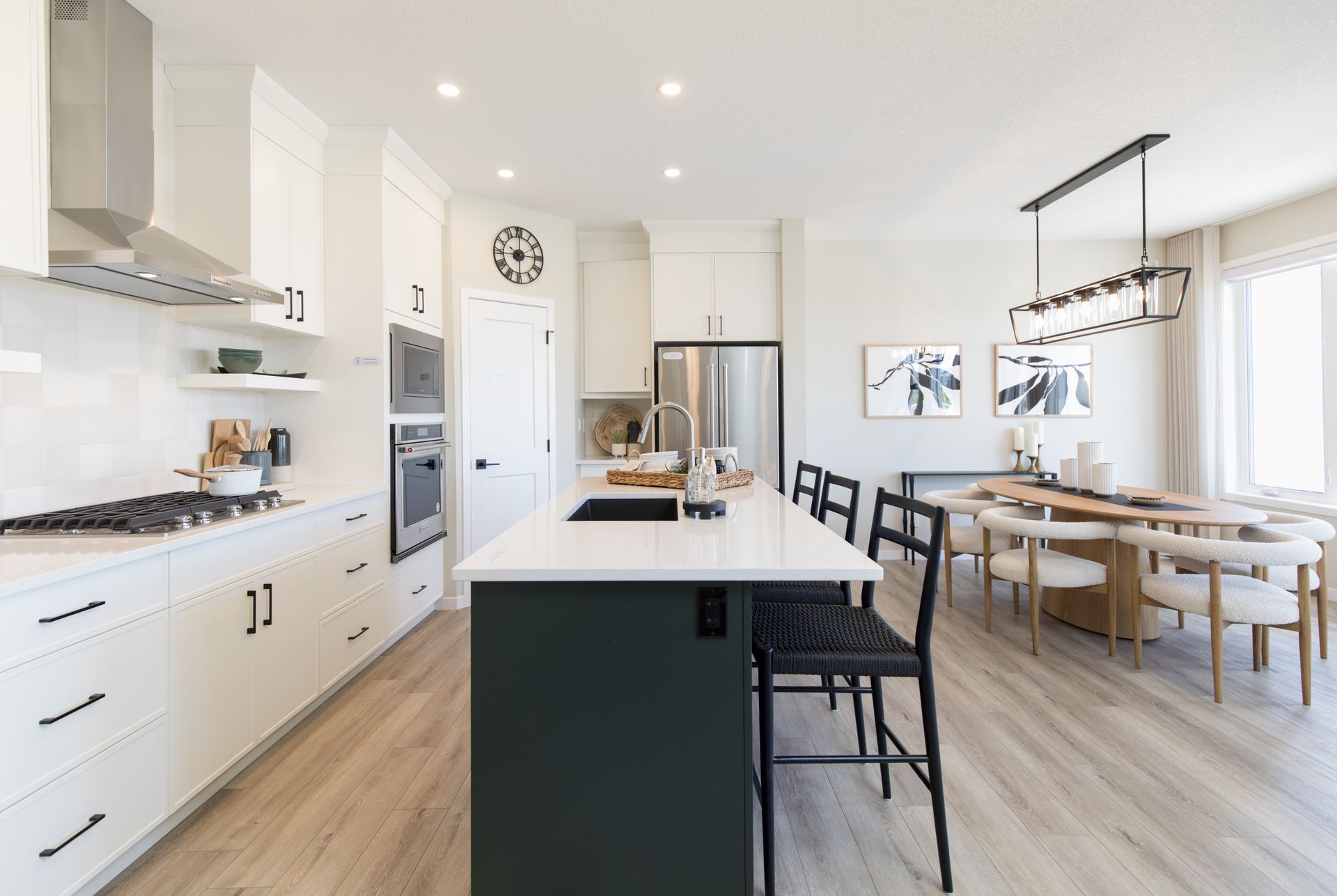 A kitchen with white cabinets and a large island in the middle.