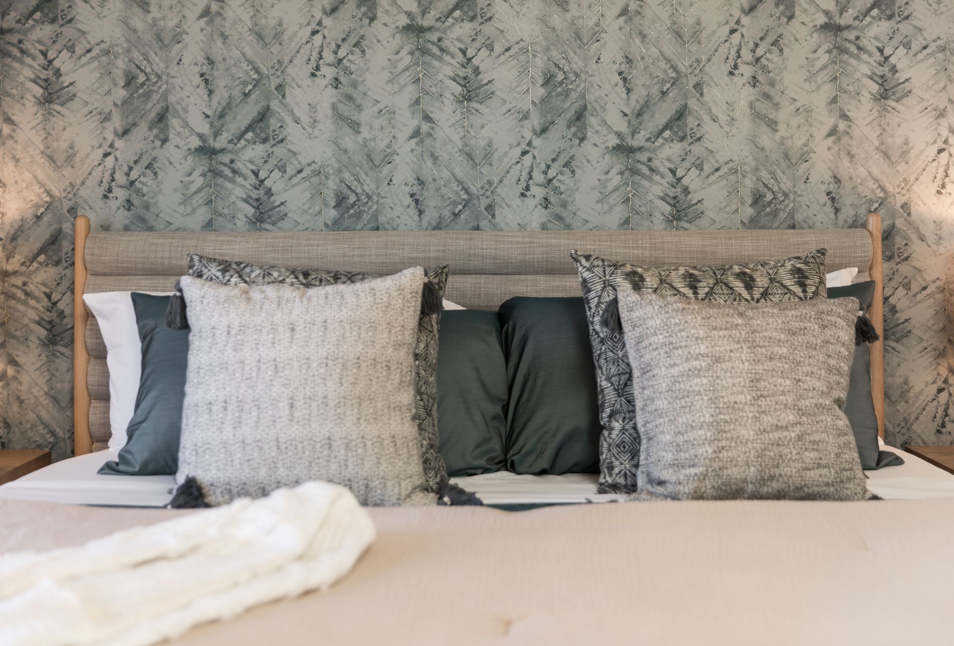 A bed with lots of pillows on it in a bedroom.