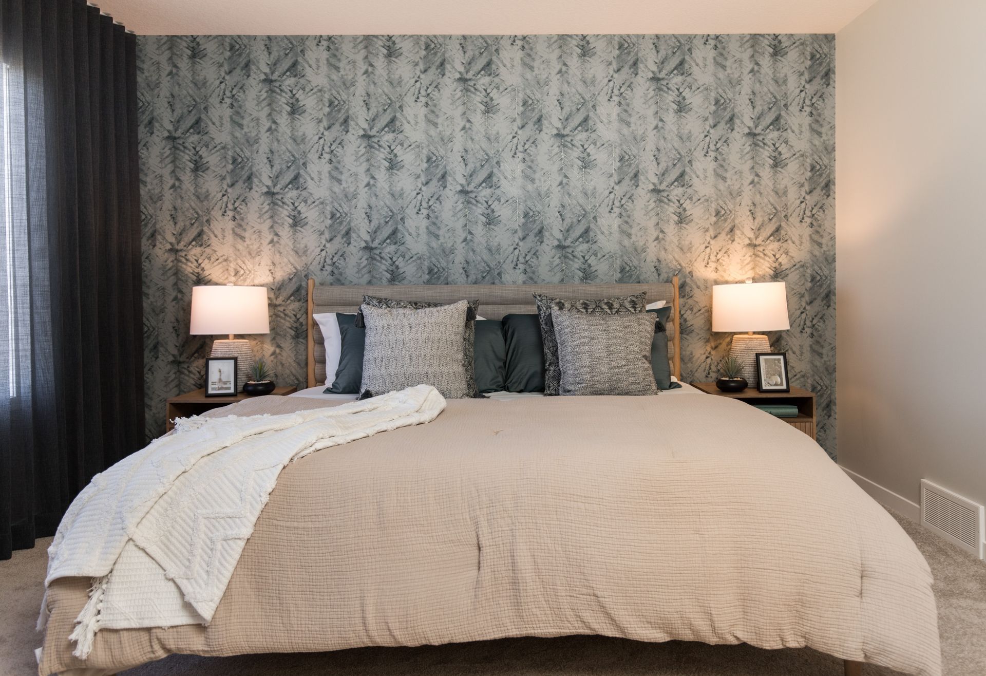 A bedroom with a large bed and two lamps