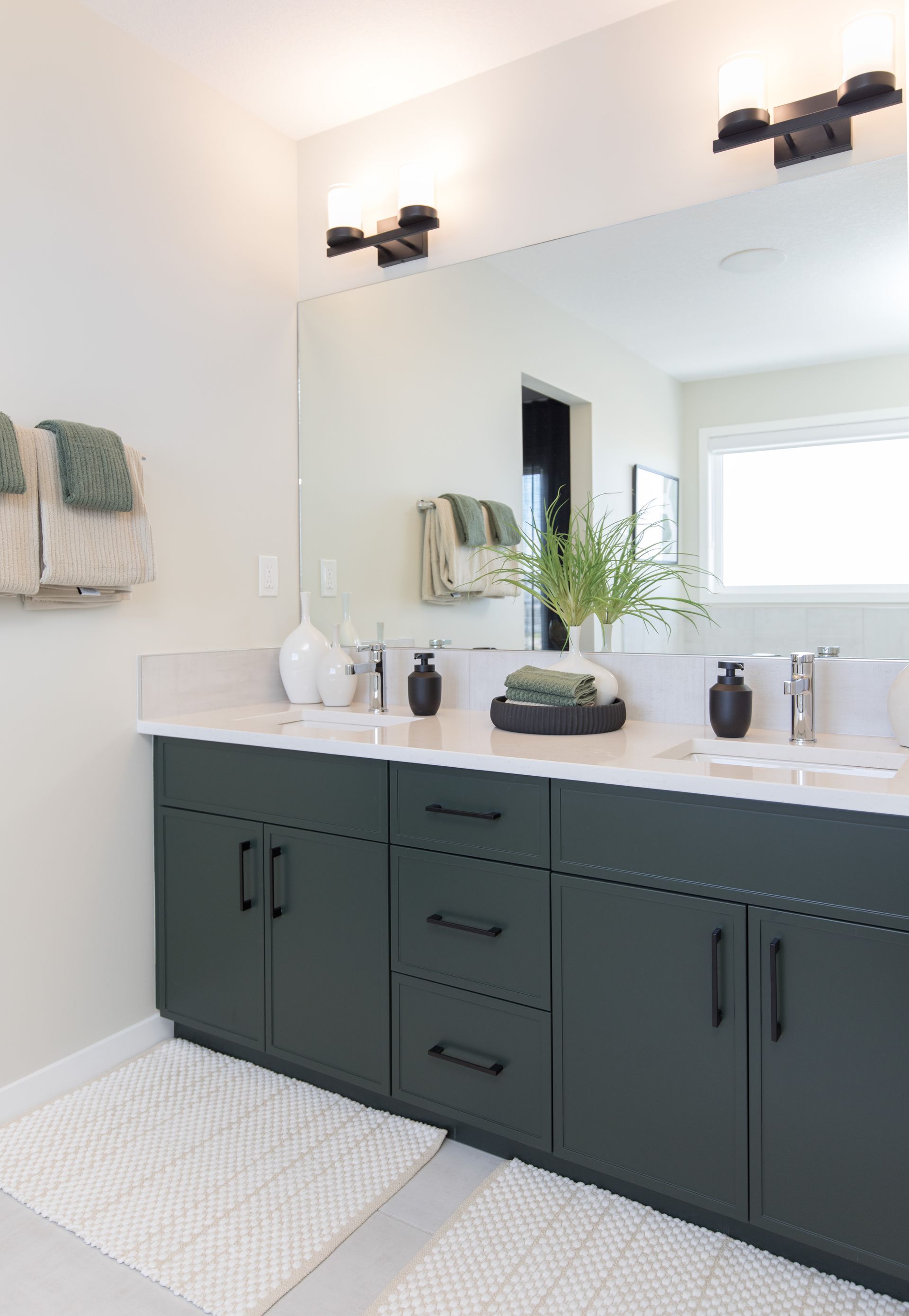 A bathroom with two sinks and a large mirror.